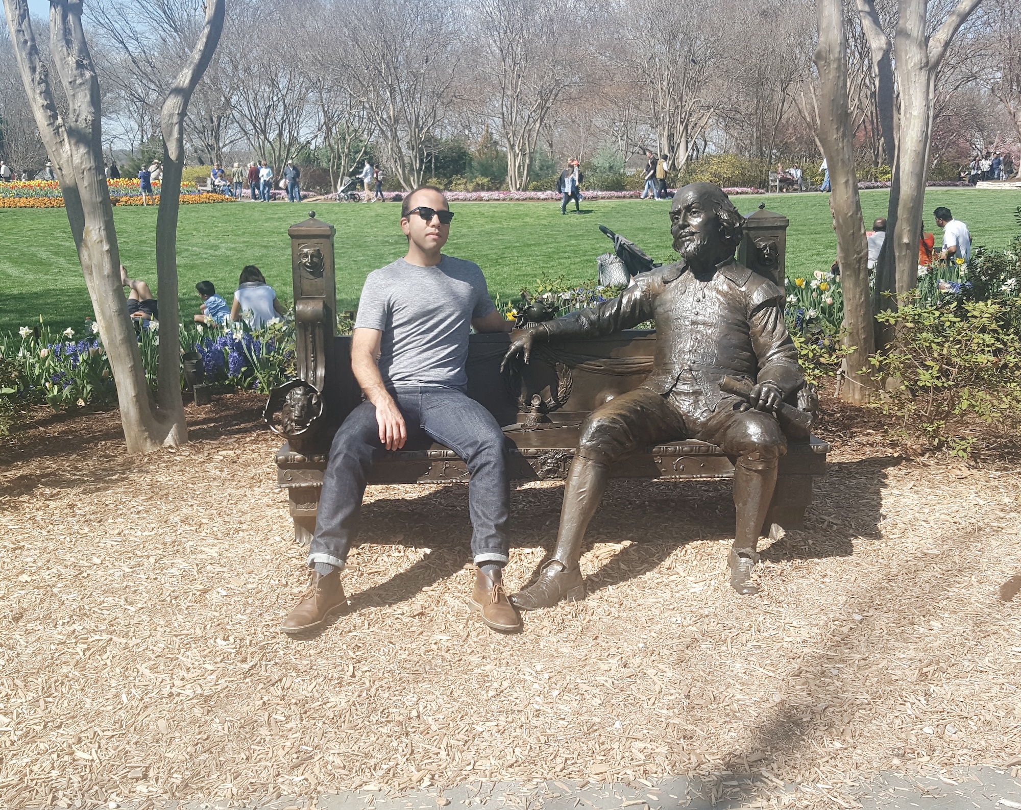 Michael sits with a statue at the botanical gardens