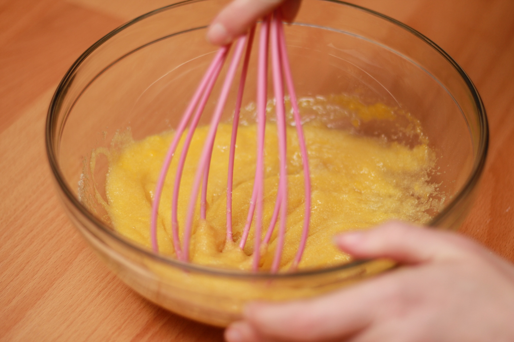 Alyssa whisks an egg into a bowl of sugar