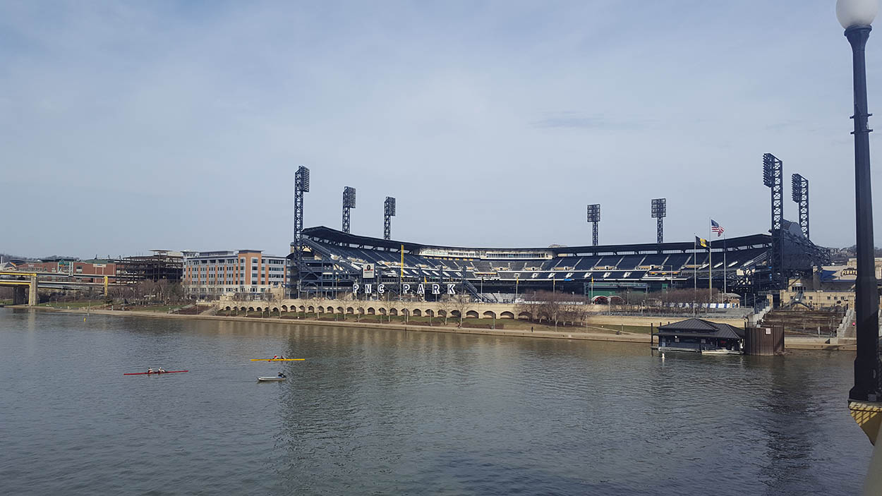View of Acrisure Stadium from across the river, with kayakers in the foreground