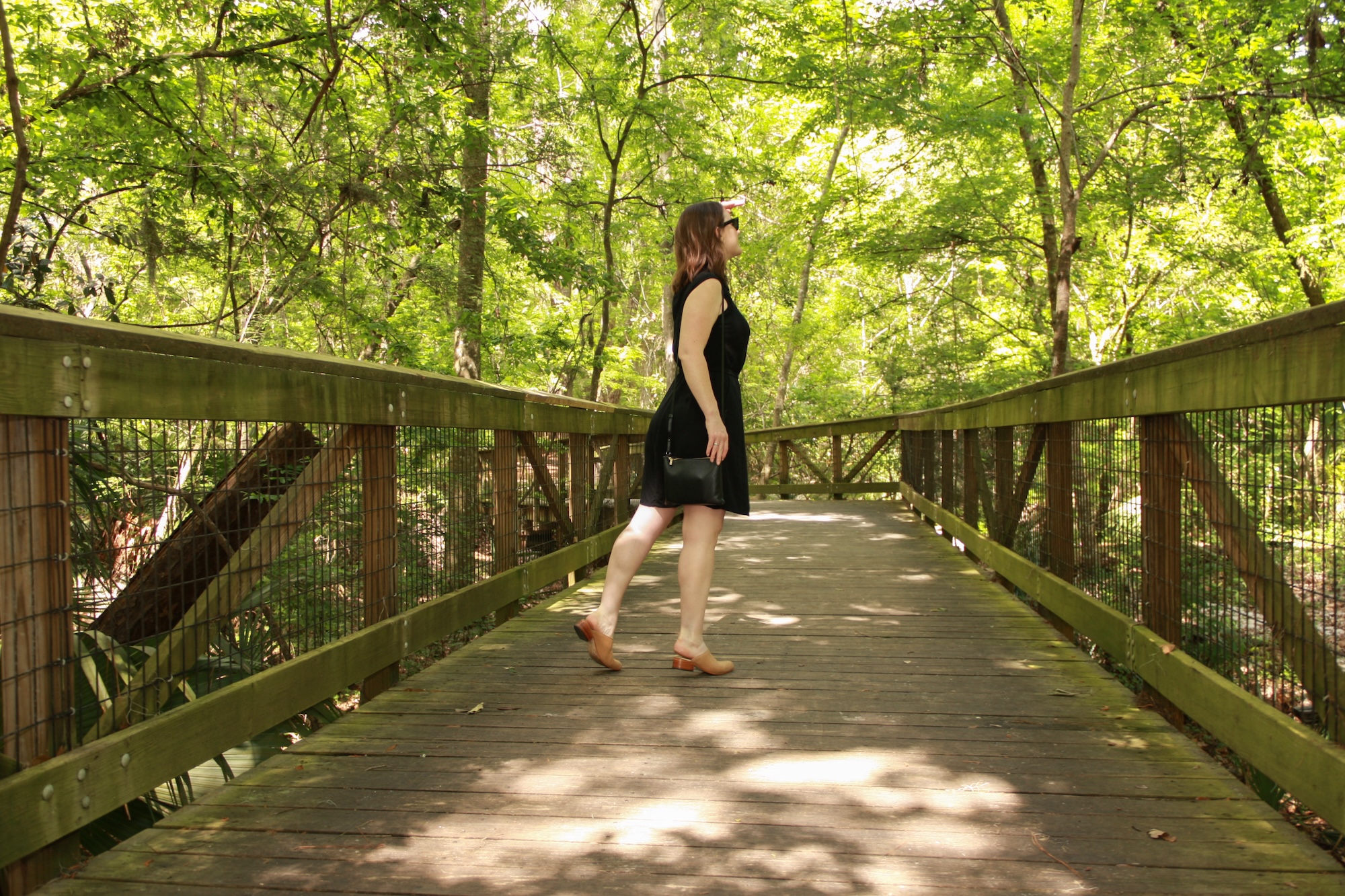 Alyssa wears a black shirtdress with nude mules and a black crossbody bag