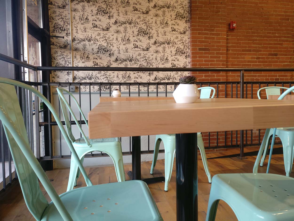 Pale blue chairs and wooden tables at De Fer Coffee and Tea