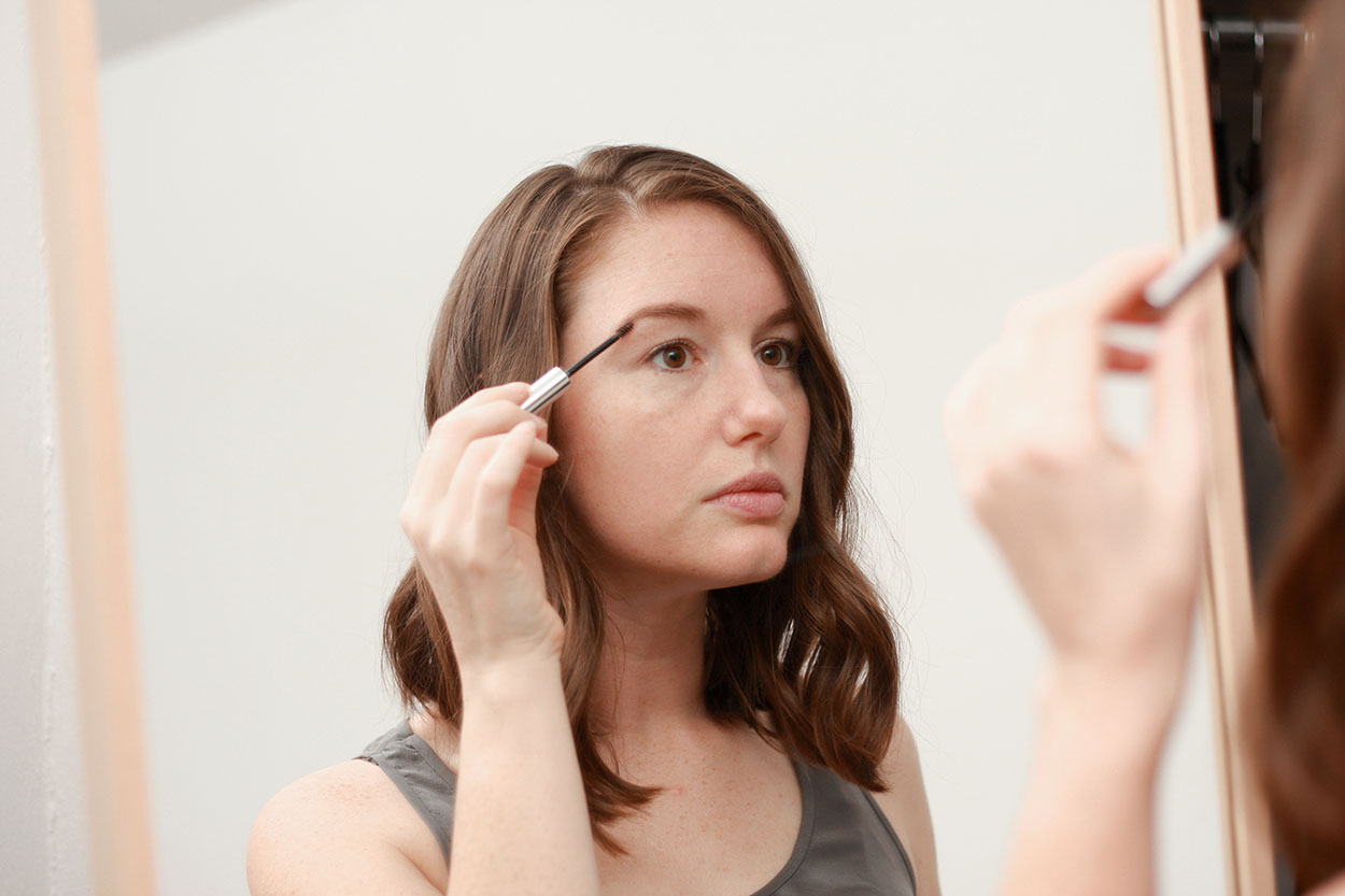 Alyssa applies Boy Brow from Glossier to her eyebrows