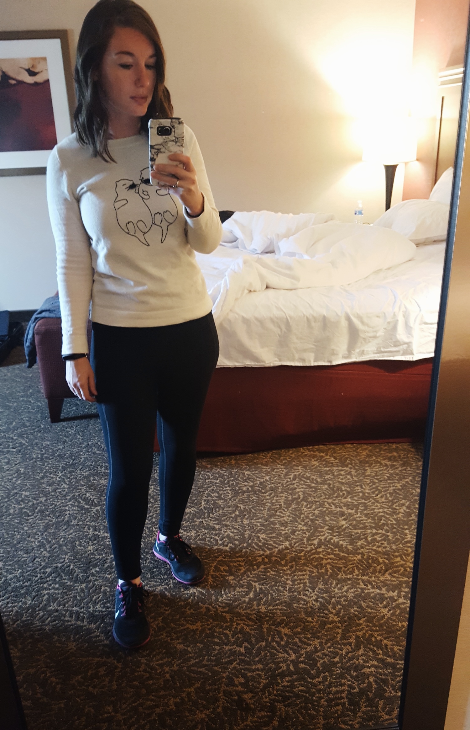 Alyssa wears an otter sweater with leggings and sneakers