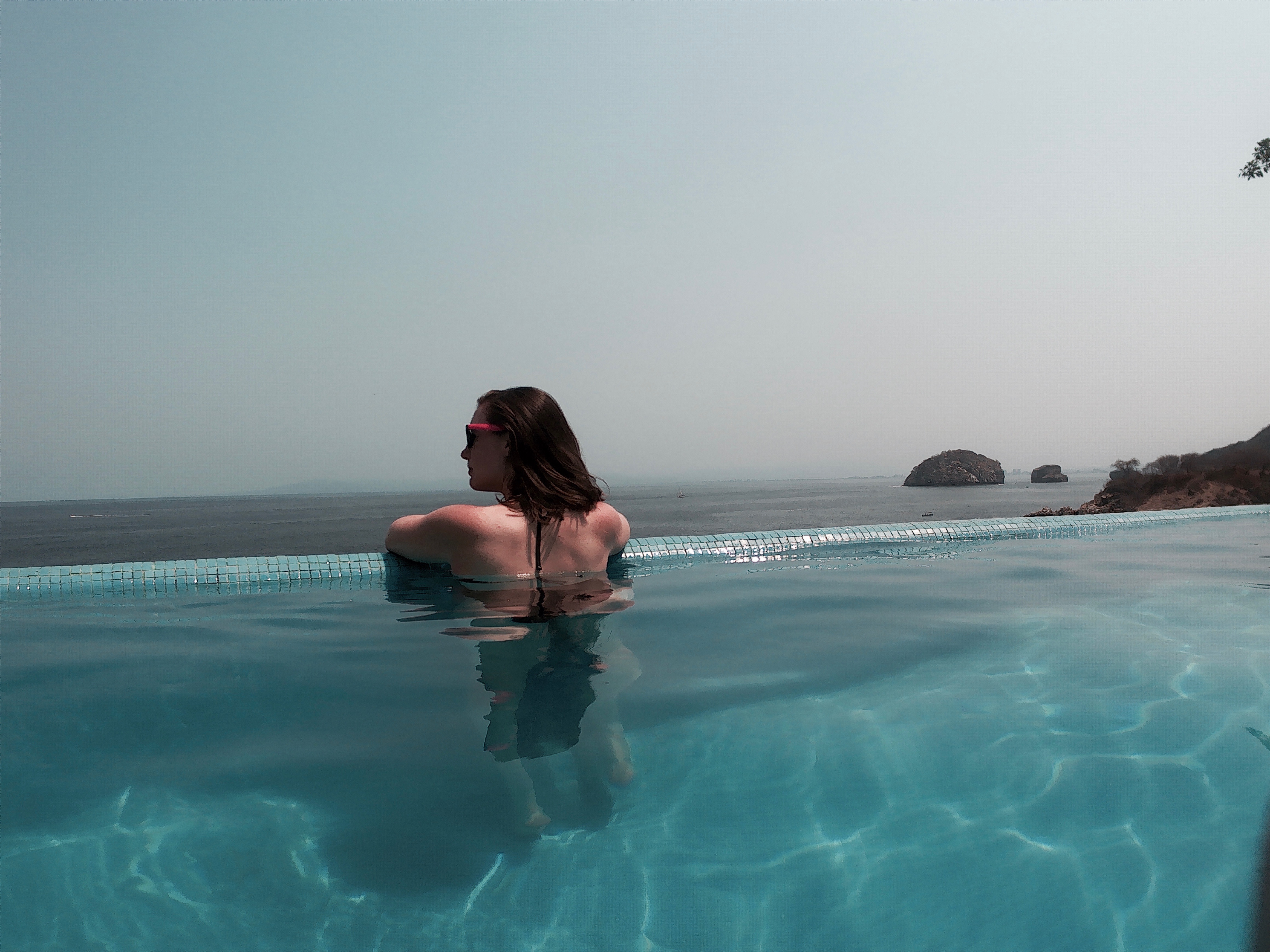 Alyssa looks out over the ocean from an infinity pool