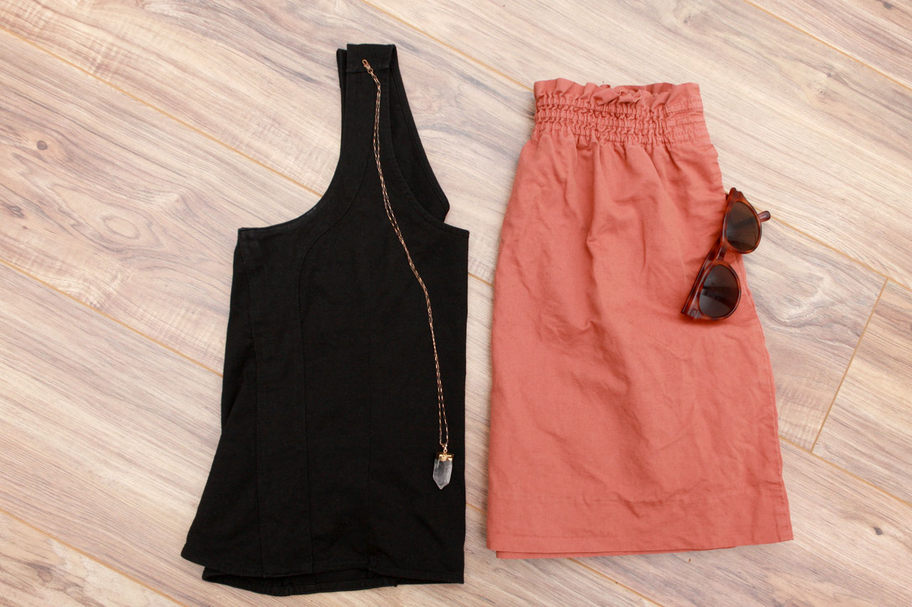 A black tank, salmon skirt, and brown sunglasses