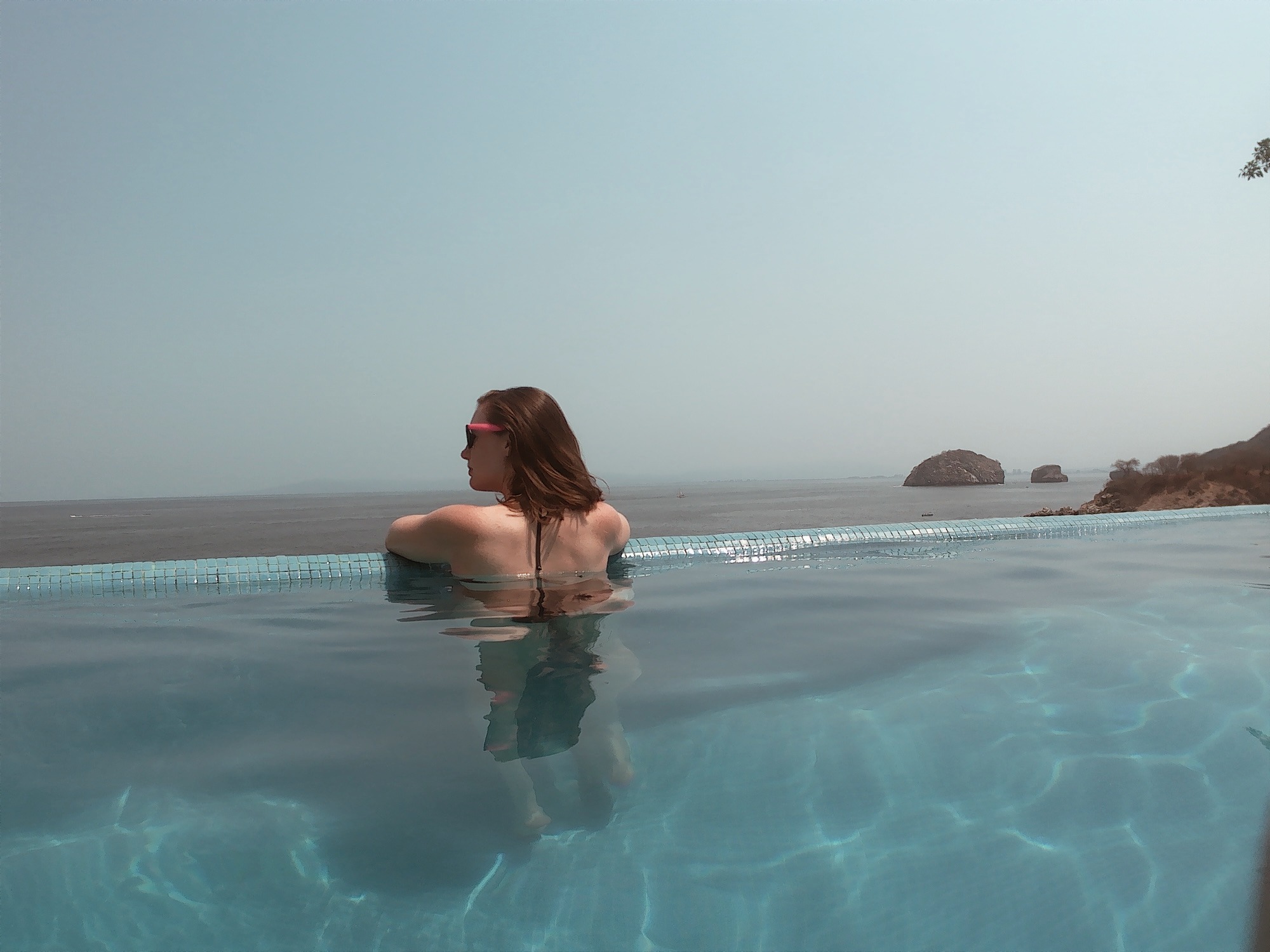 Alyssa looks out over the ocean from an infinity pool
