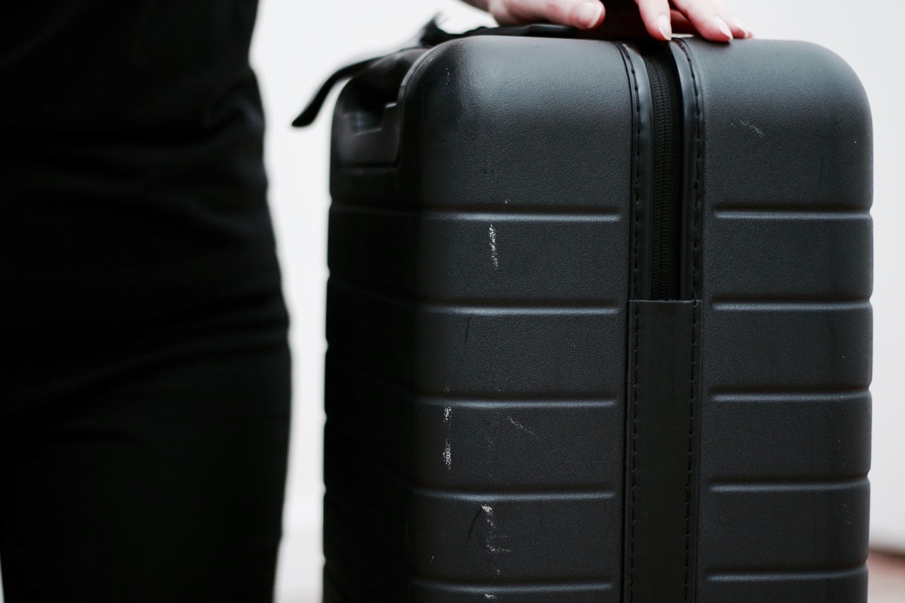 Alyssa shows the scuff marks on her Away Carry-On