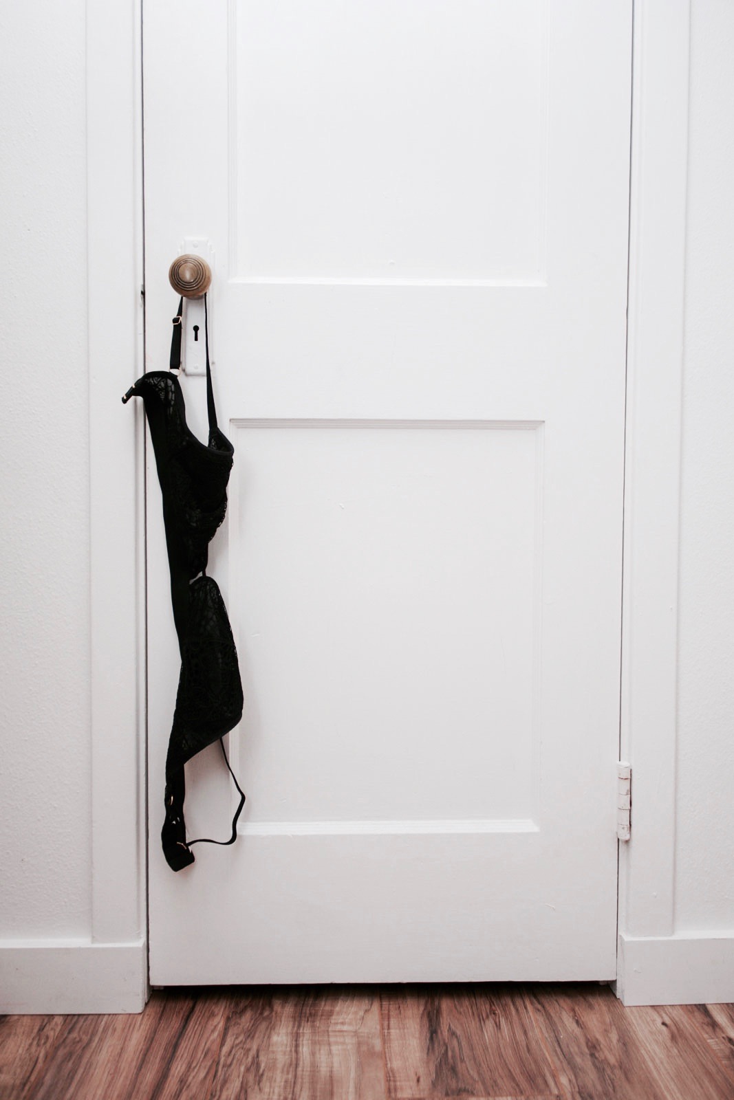 A bralette hangs on a doorknob