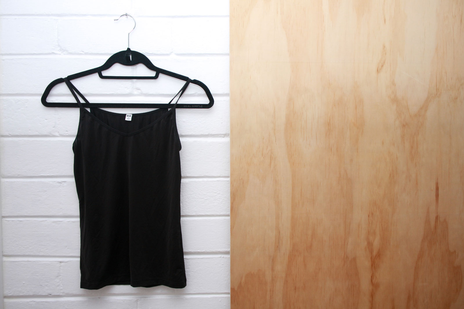 A Uniqlo Airism Camisole hangs on a hanger
