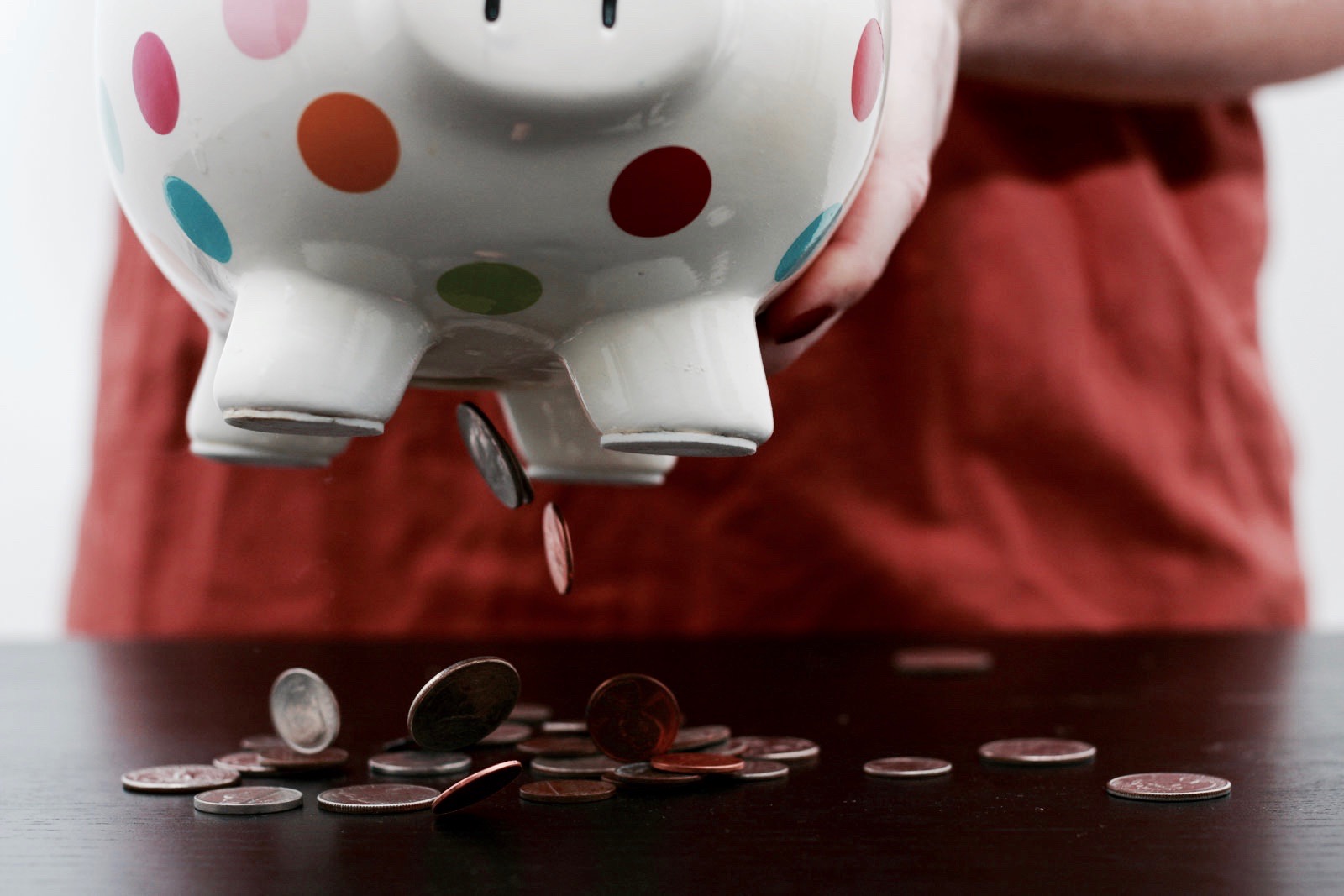 Alyssa shakes a piggy bank to empty its coins