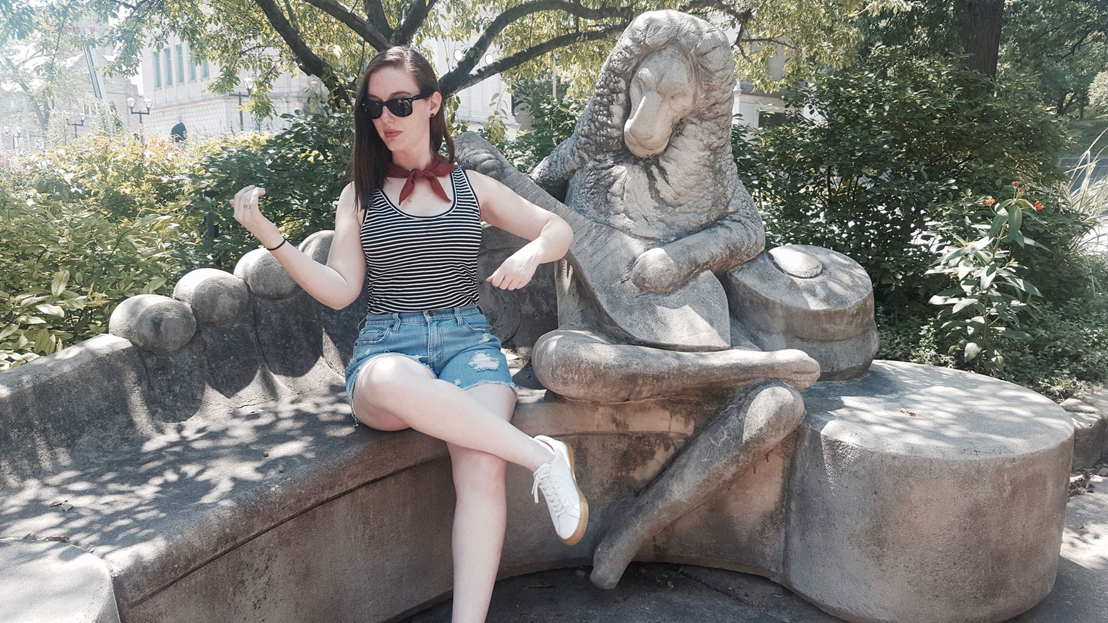 Alyssa pretends to play the lute with a statue