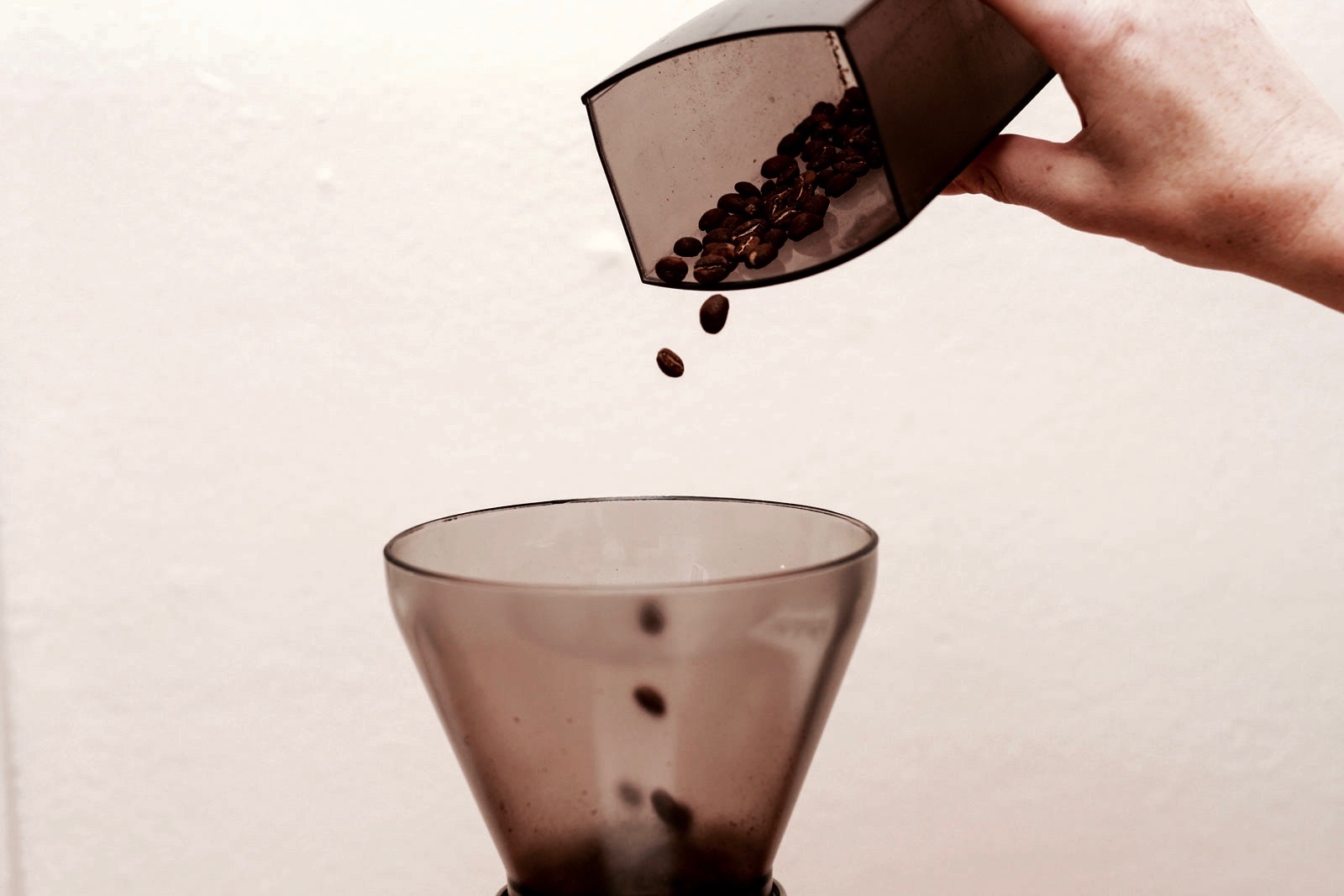 Pouring coffee into a grinder hopper