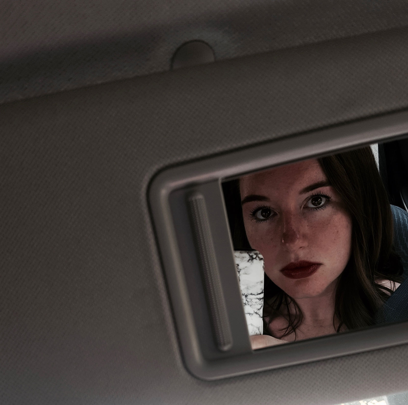 Alyssa is wearing an Ilia Lipstick in the car mirror