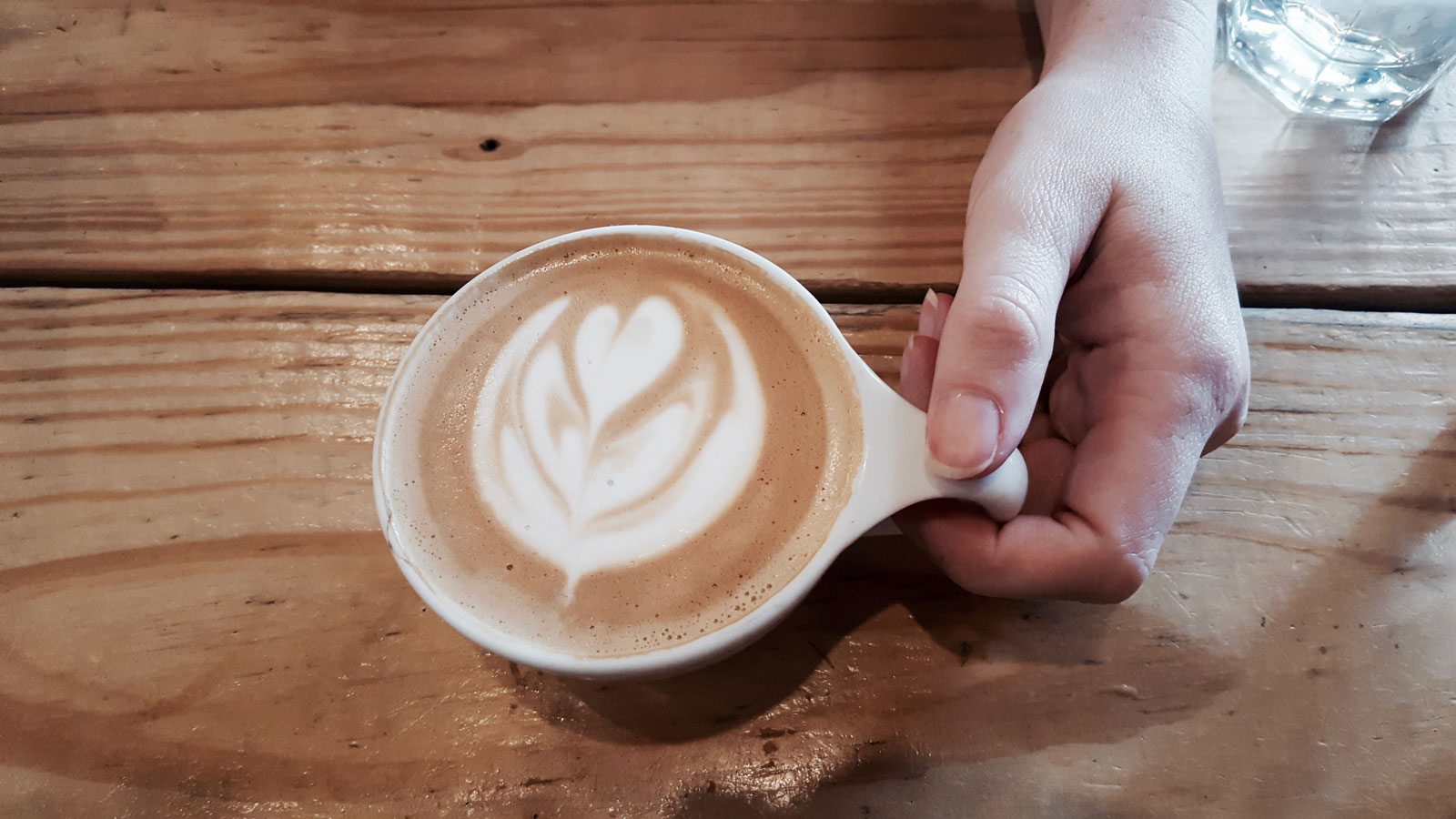 Alyssa holds a cappuccino at BREW