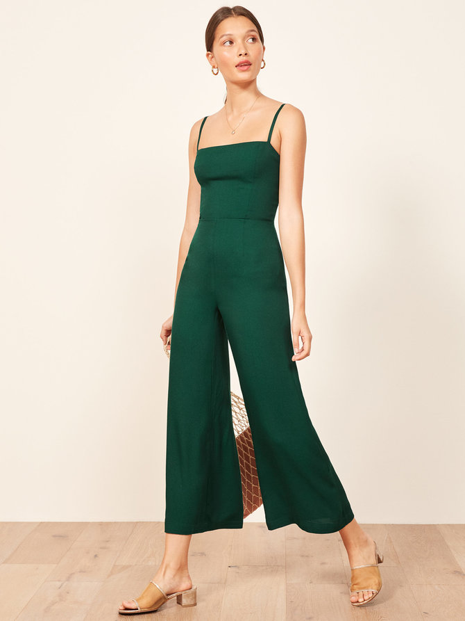 A model in an emerald green jumpsuit