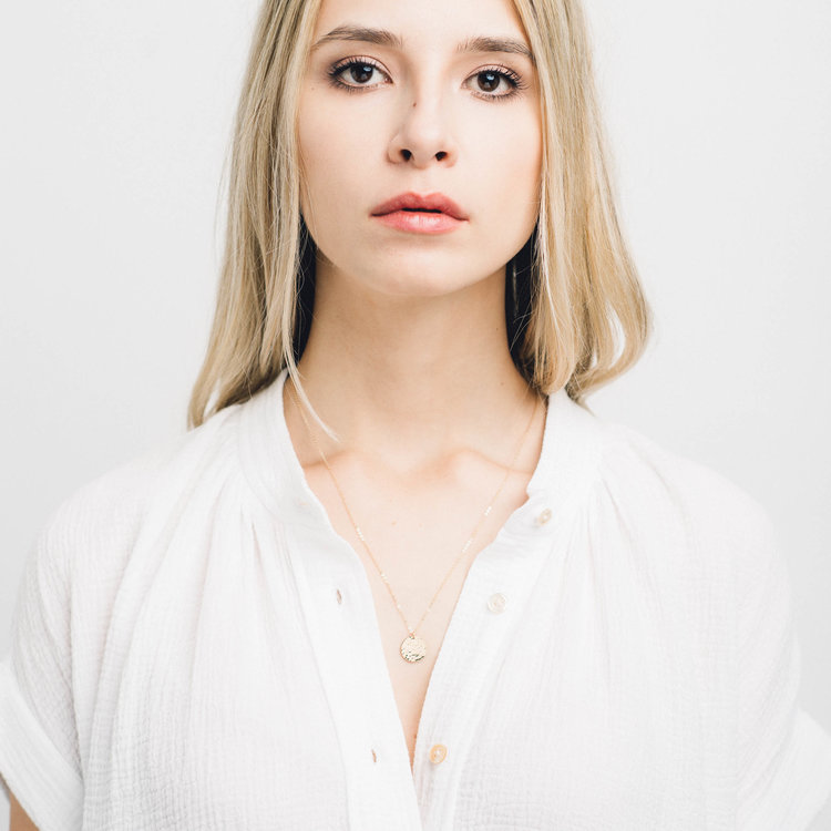 A model with a gold pendant necklace