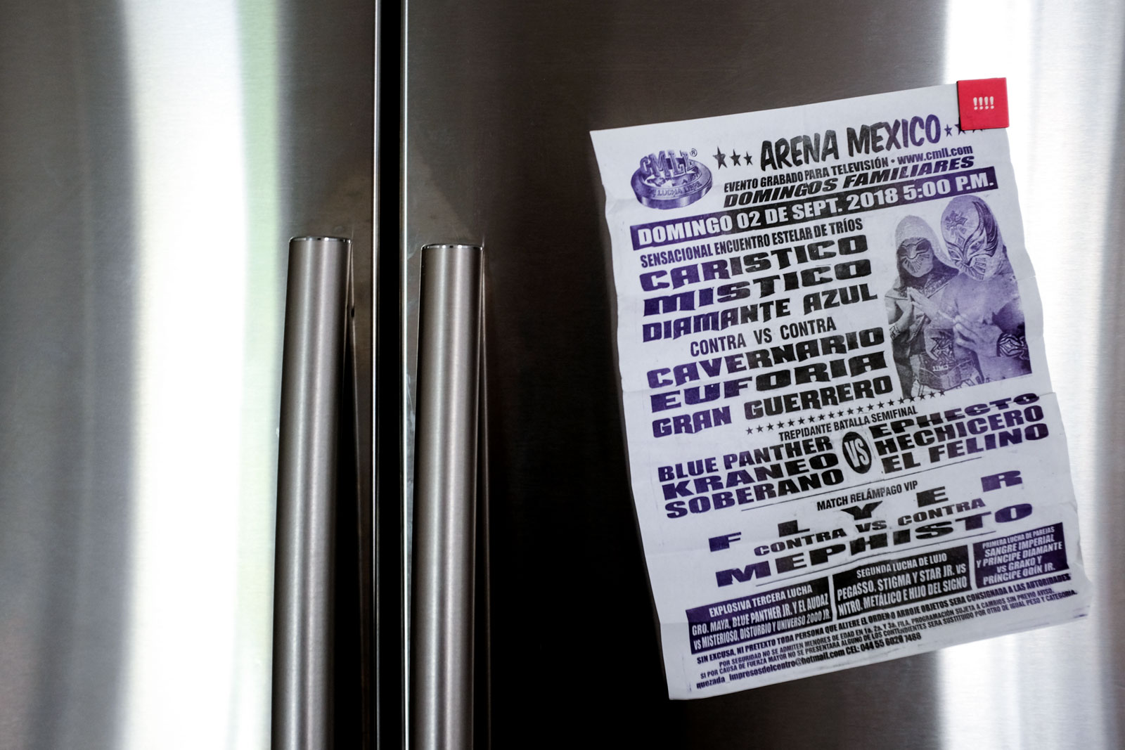 A Lucha Flyer hangs on a fridge