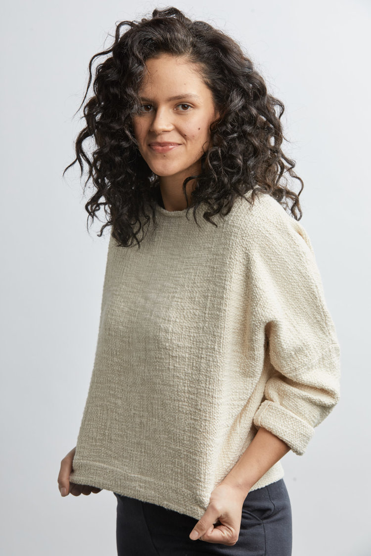 A model in a white woven oversized top