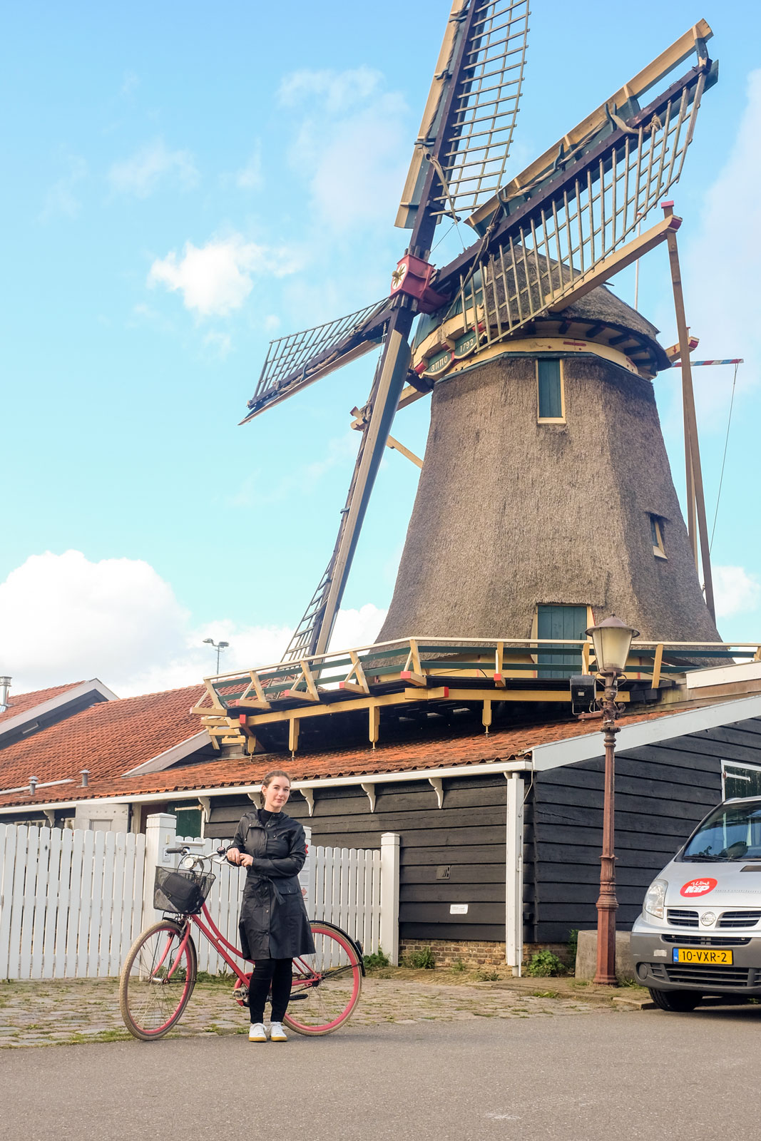 Alyssa with a bike near a windmill in Amsterdam
