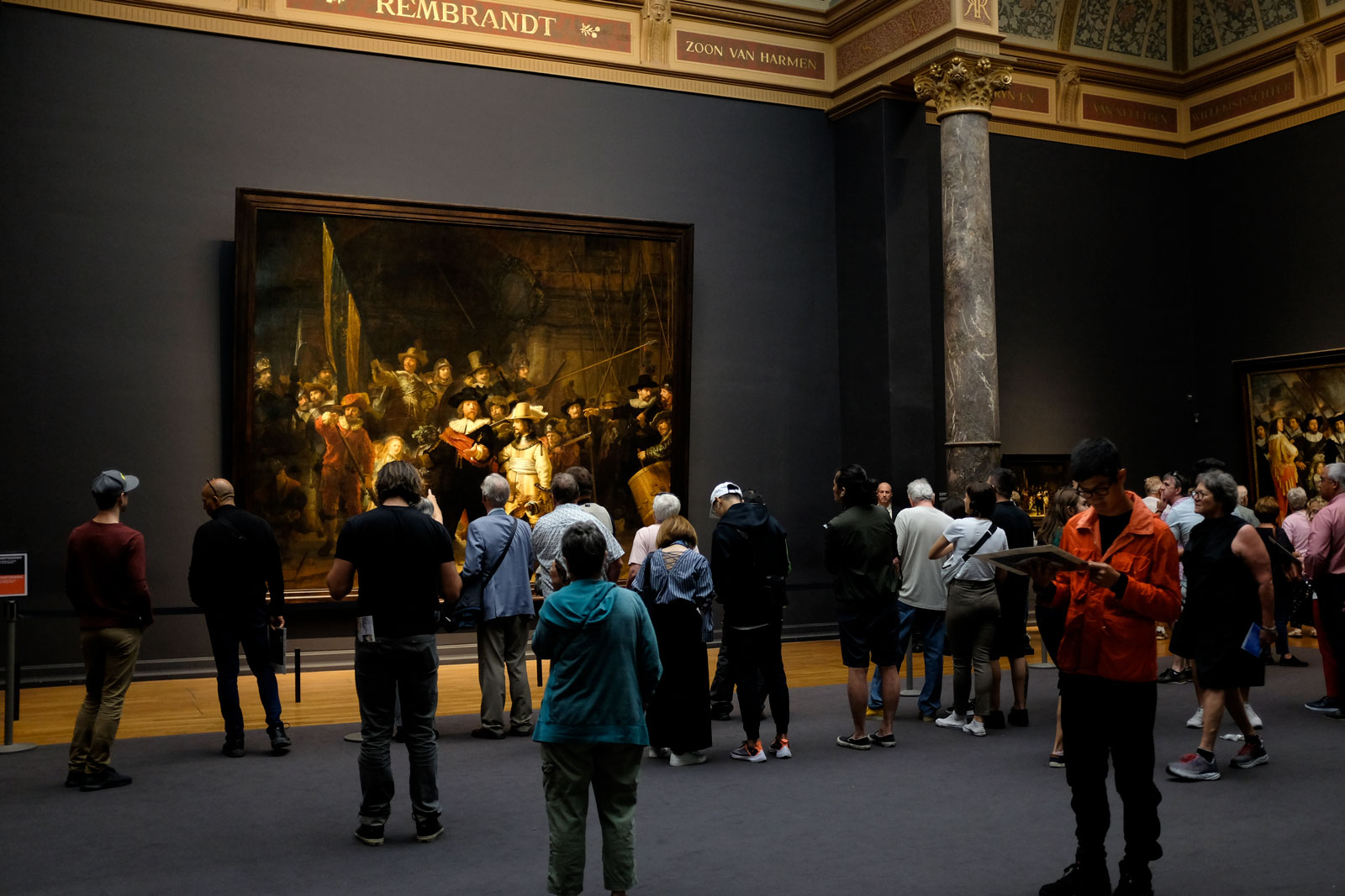 A crowd of onlookers at the Rijksmuseum in front of The Night Watch