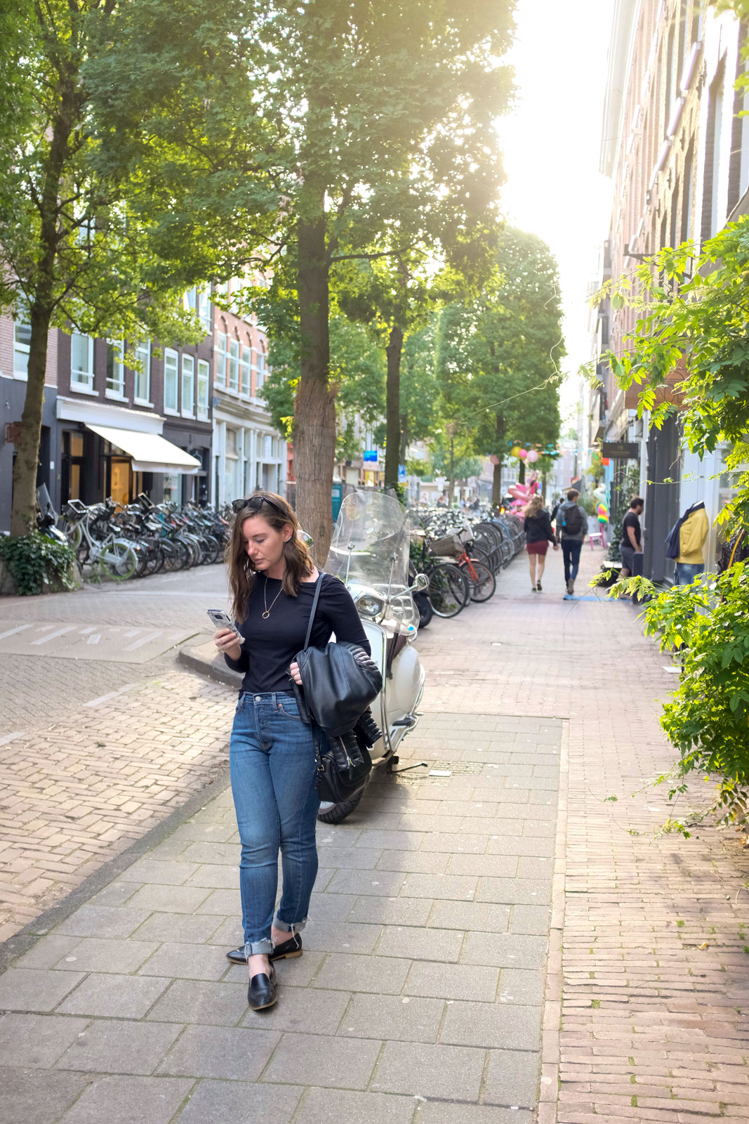 Alyssa pulls up a map on her phone while shopping in Amsterdam