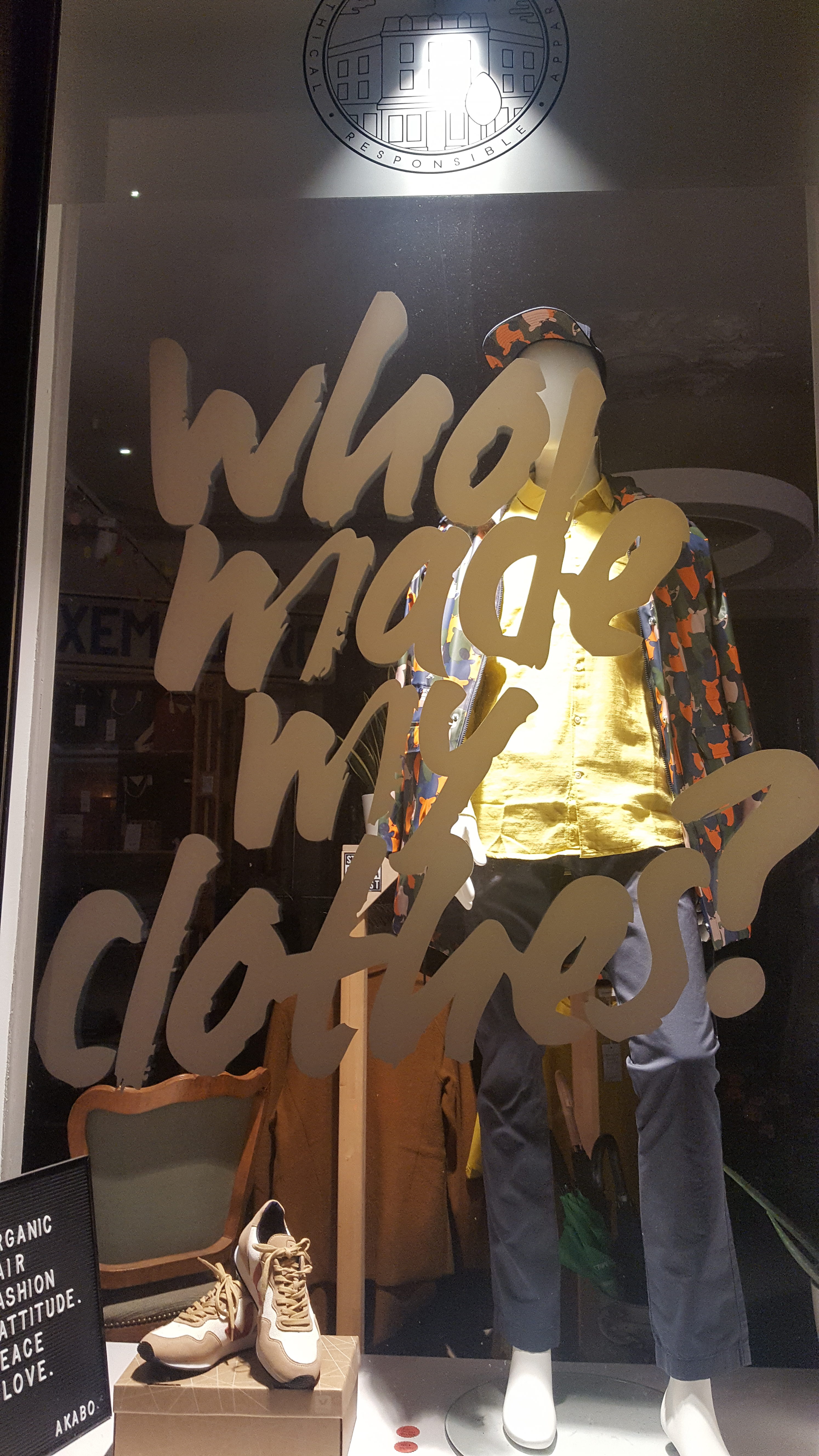 Window art at Akabo Buttek that reads "who made my clothes?"