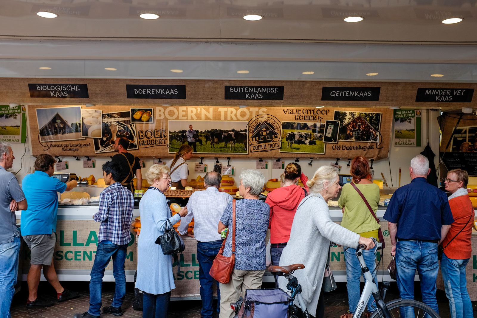 A crowd orders cheese at a Delft Market stand