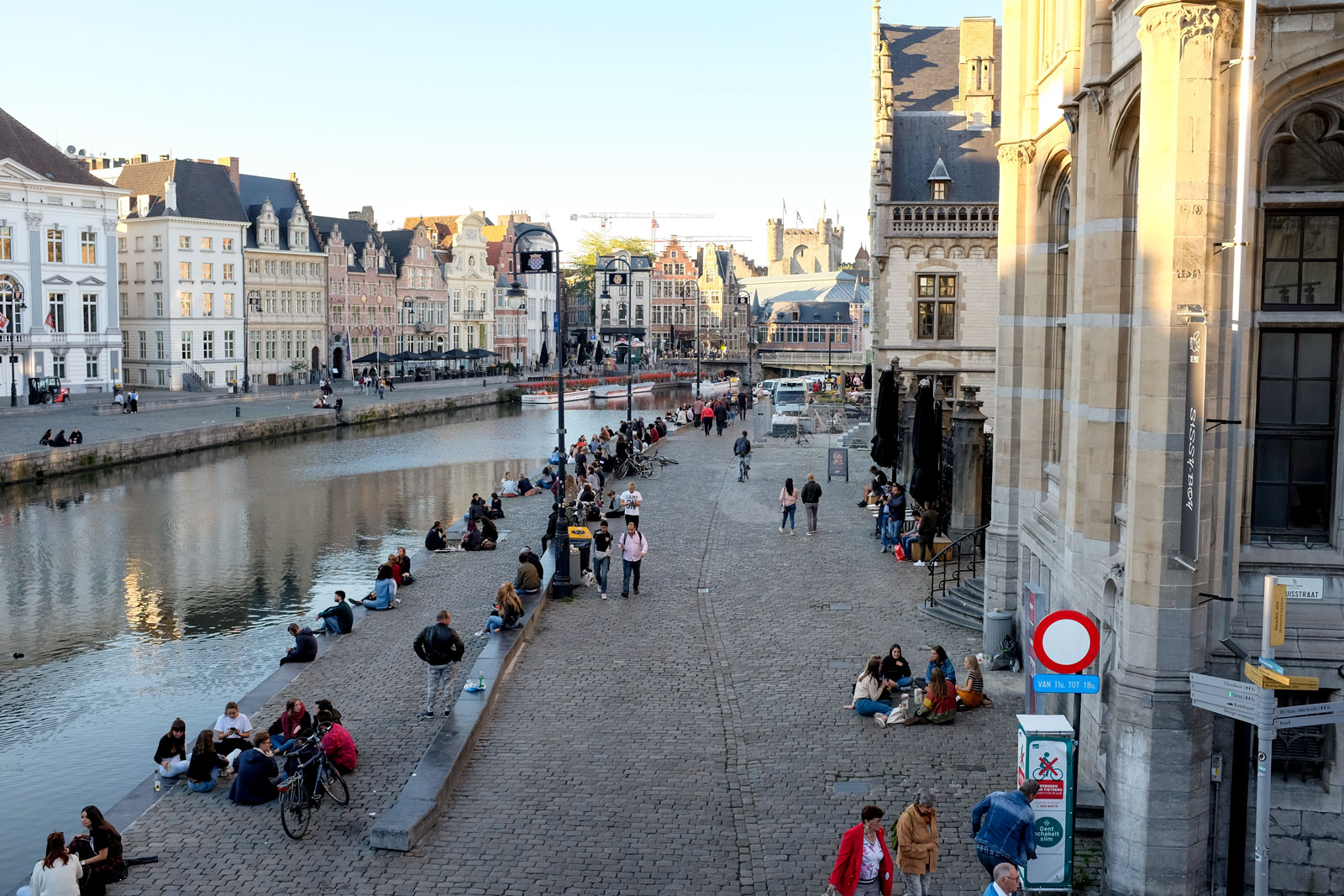 People hang out along the water in Ghent