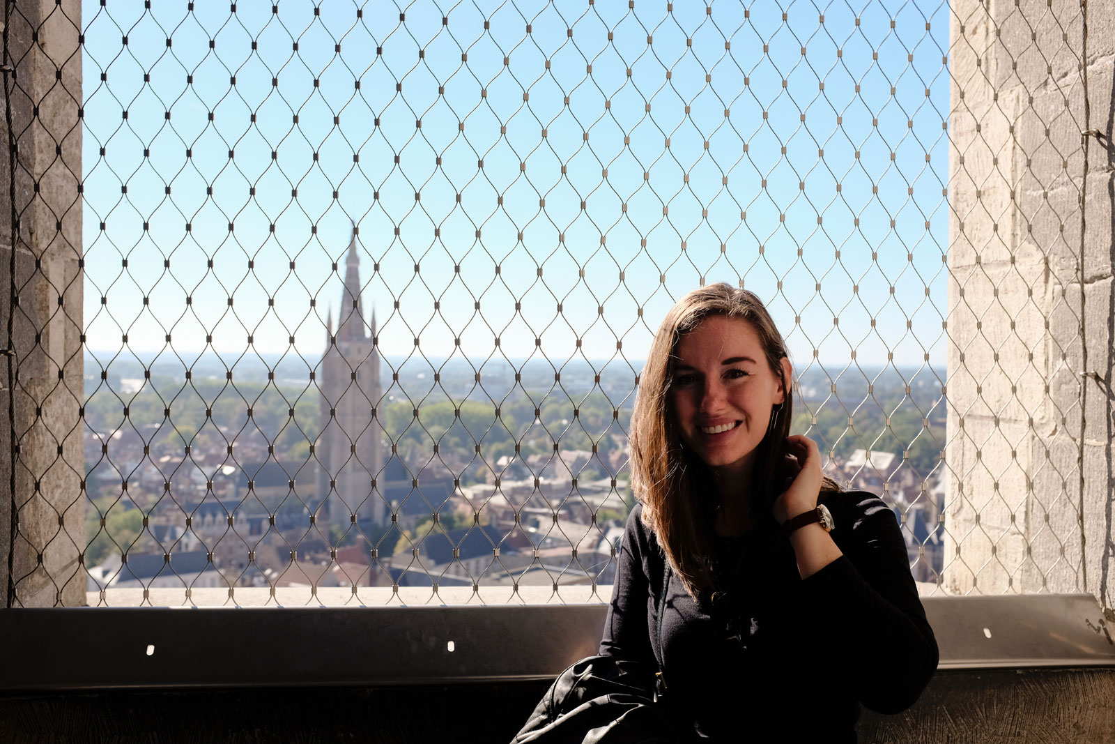 Alyssa stands at the top of the Bruges Belfry