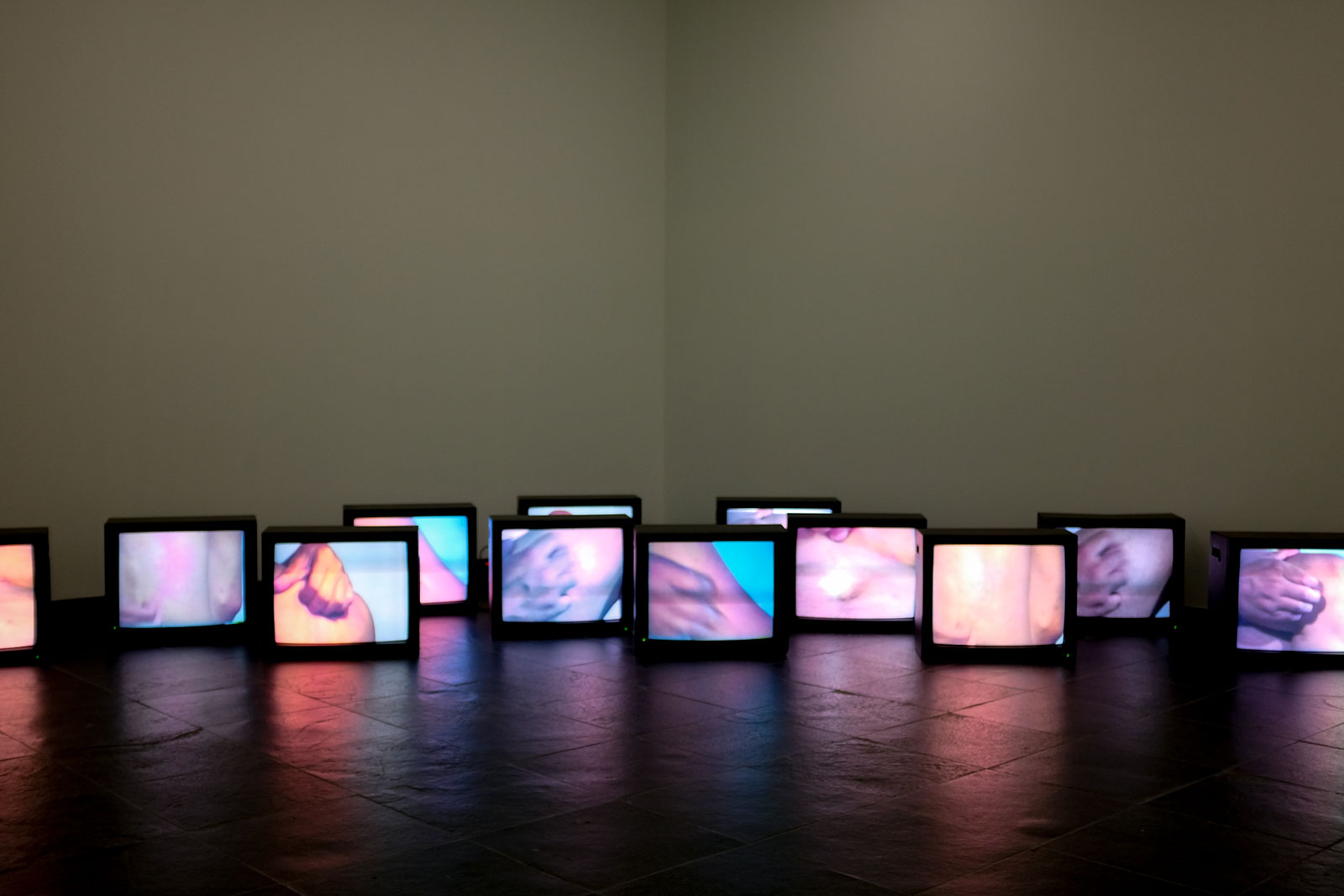 TVs showing people scratching in an art exhibit