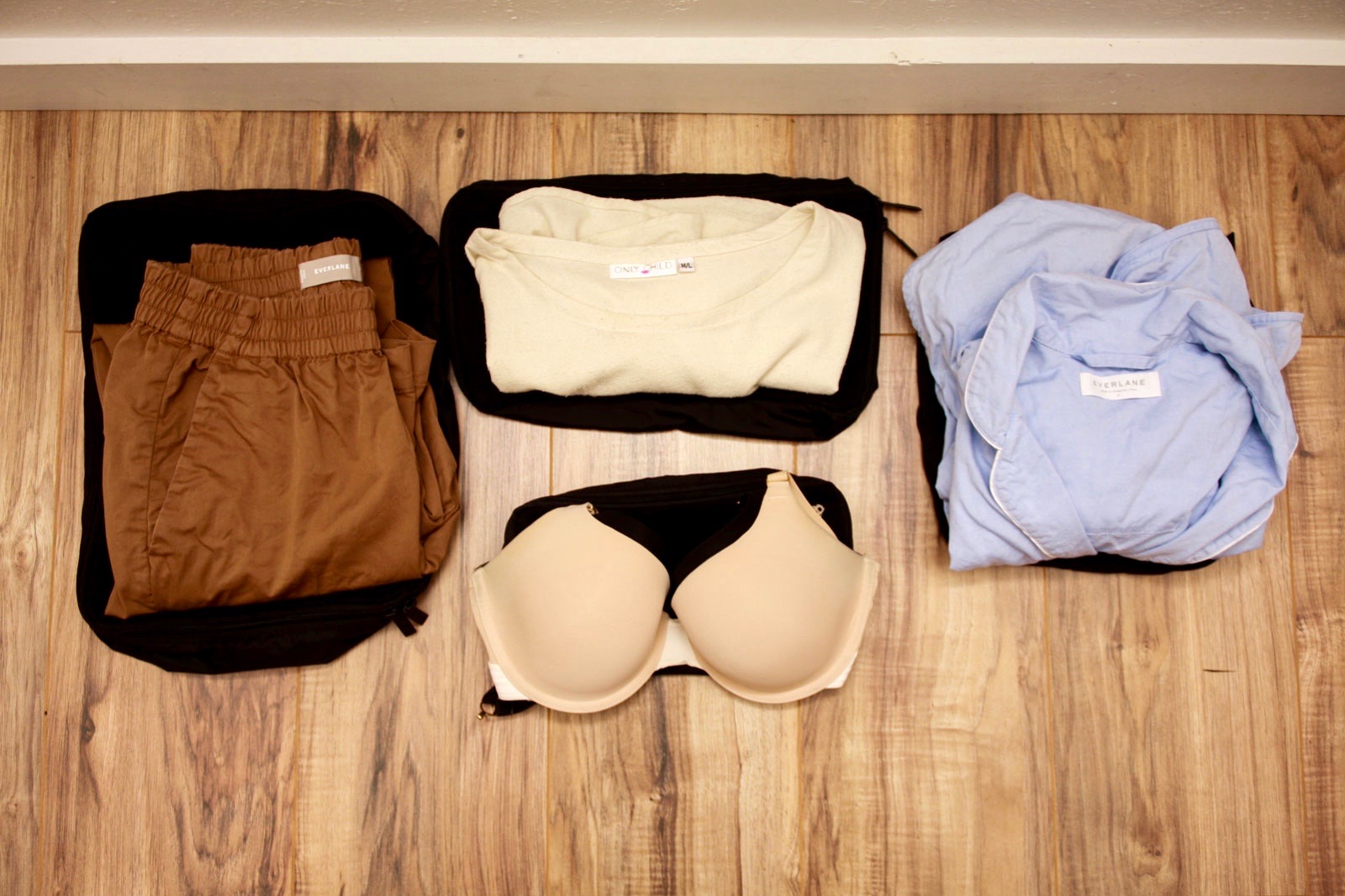 Clothing placed on top of four Away Packing Cubes