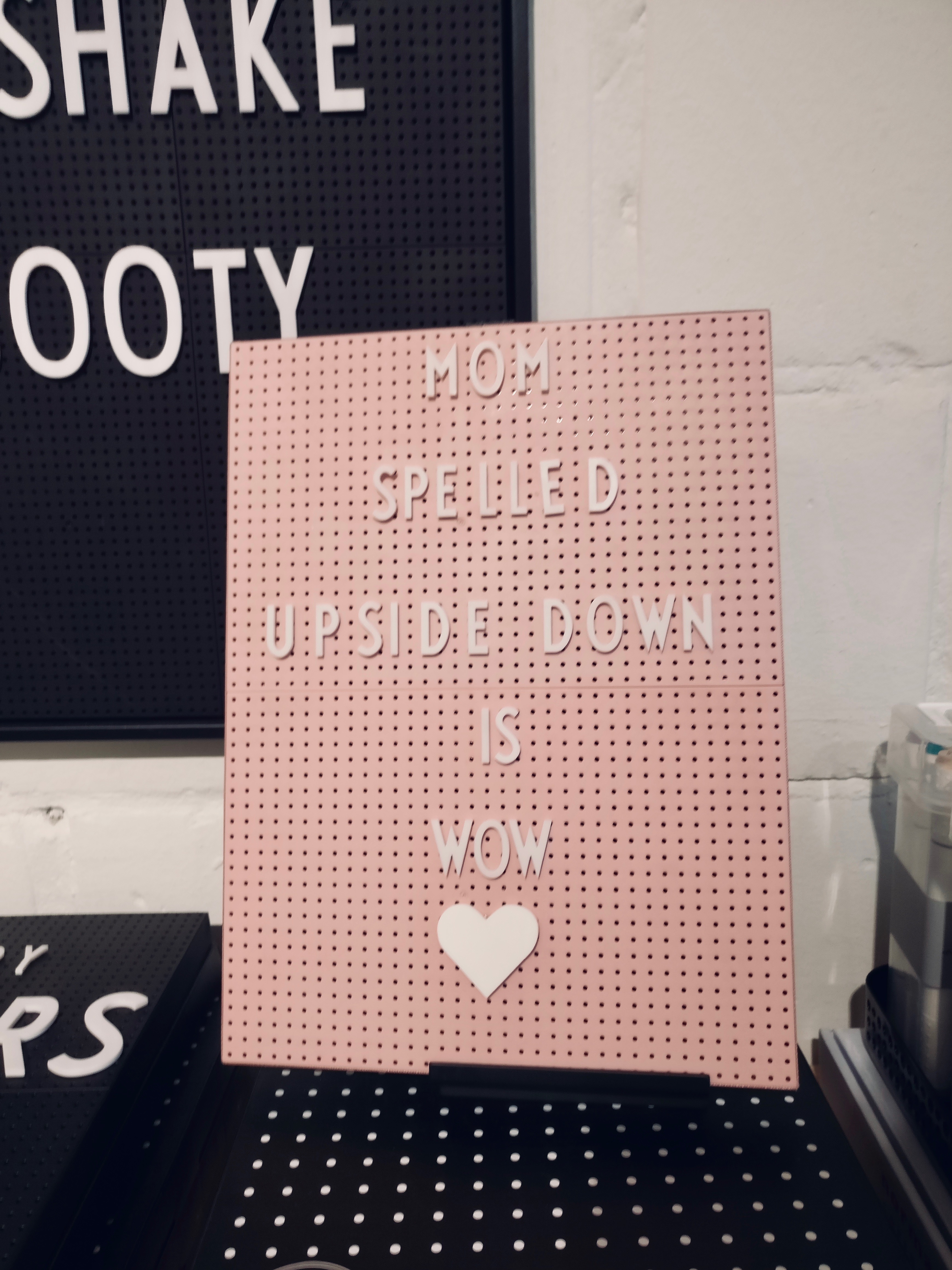 A pegboard reads "Mom spelled upside down is wow"