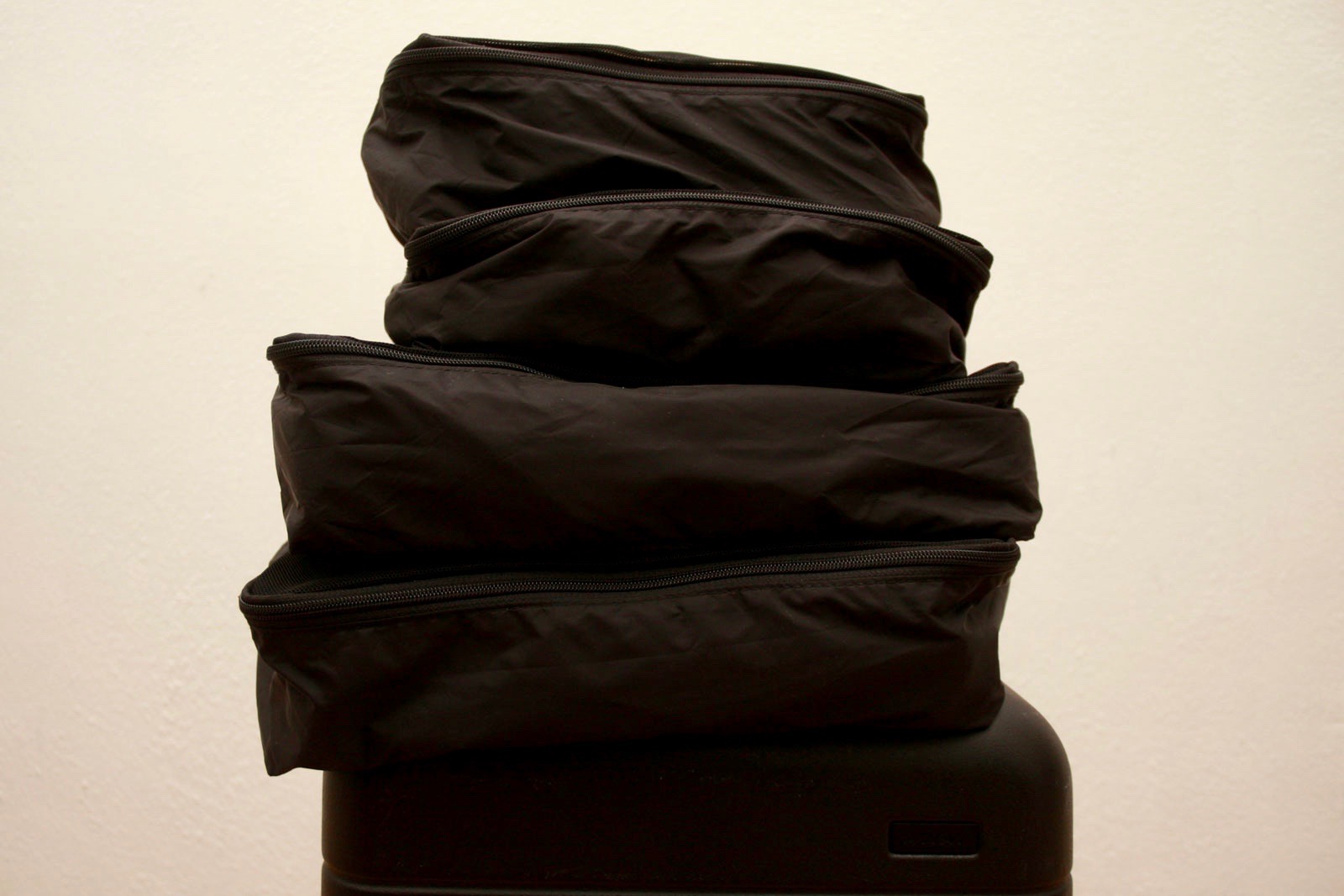 A stack of Away Packing Cubes on top of a carry-on