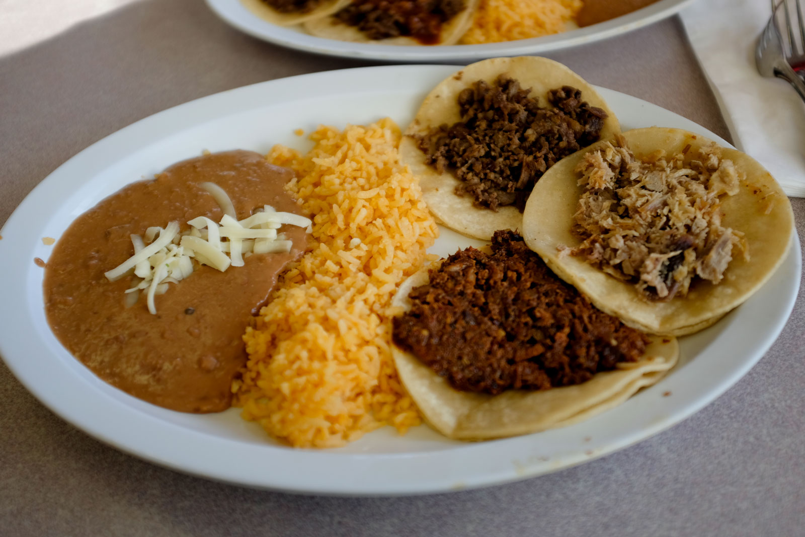 A plate of tacos, rice, and beans at El Taco de Mexico 