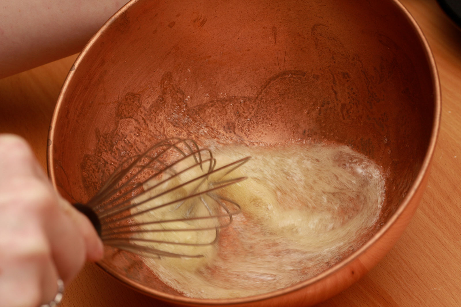 whisking egg whites in a copper bowl - foamy