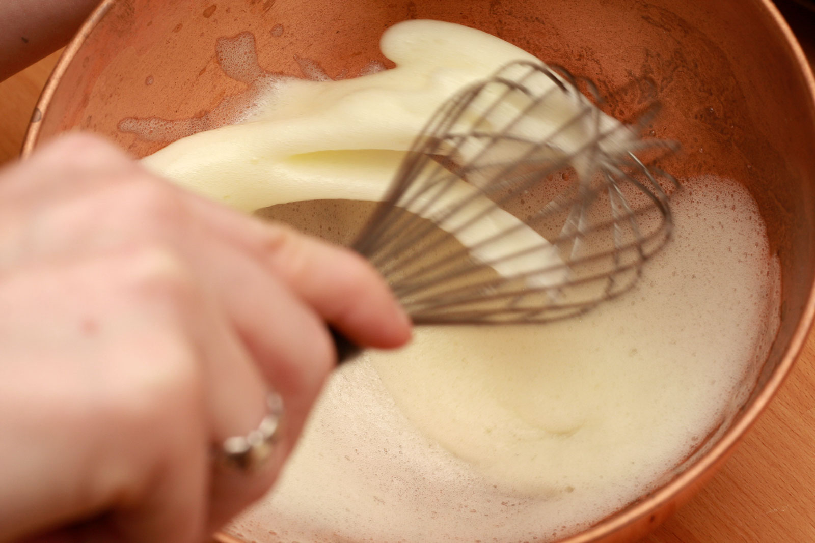 whisking egg whites in a copper bowl - soft peaks