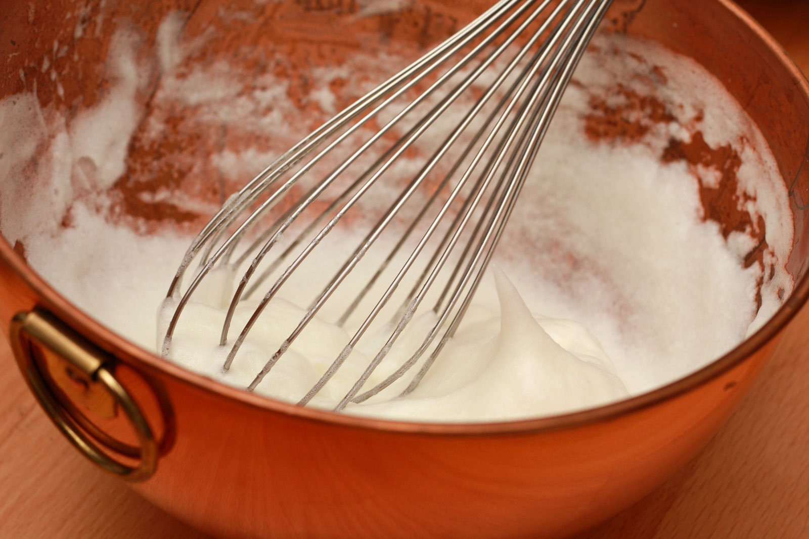 whisking egg whites in a copper bowl - stiff peaks