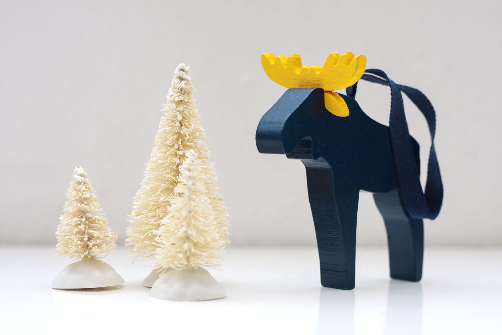 A blue and yellow Moose with three bottlebrush trees
