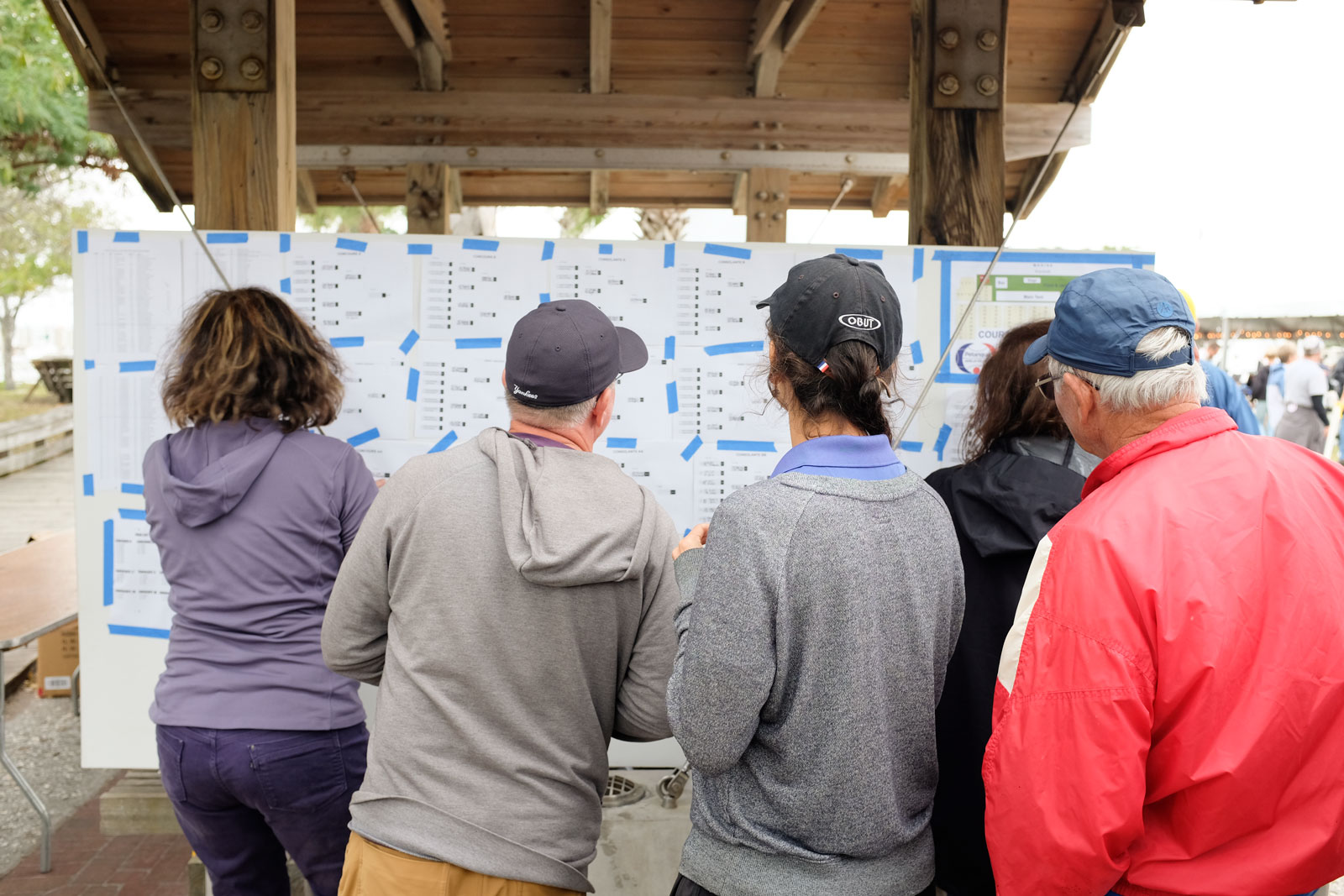 A crowd gathers to review the Pétanque game brackets at Amelia Island