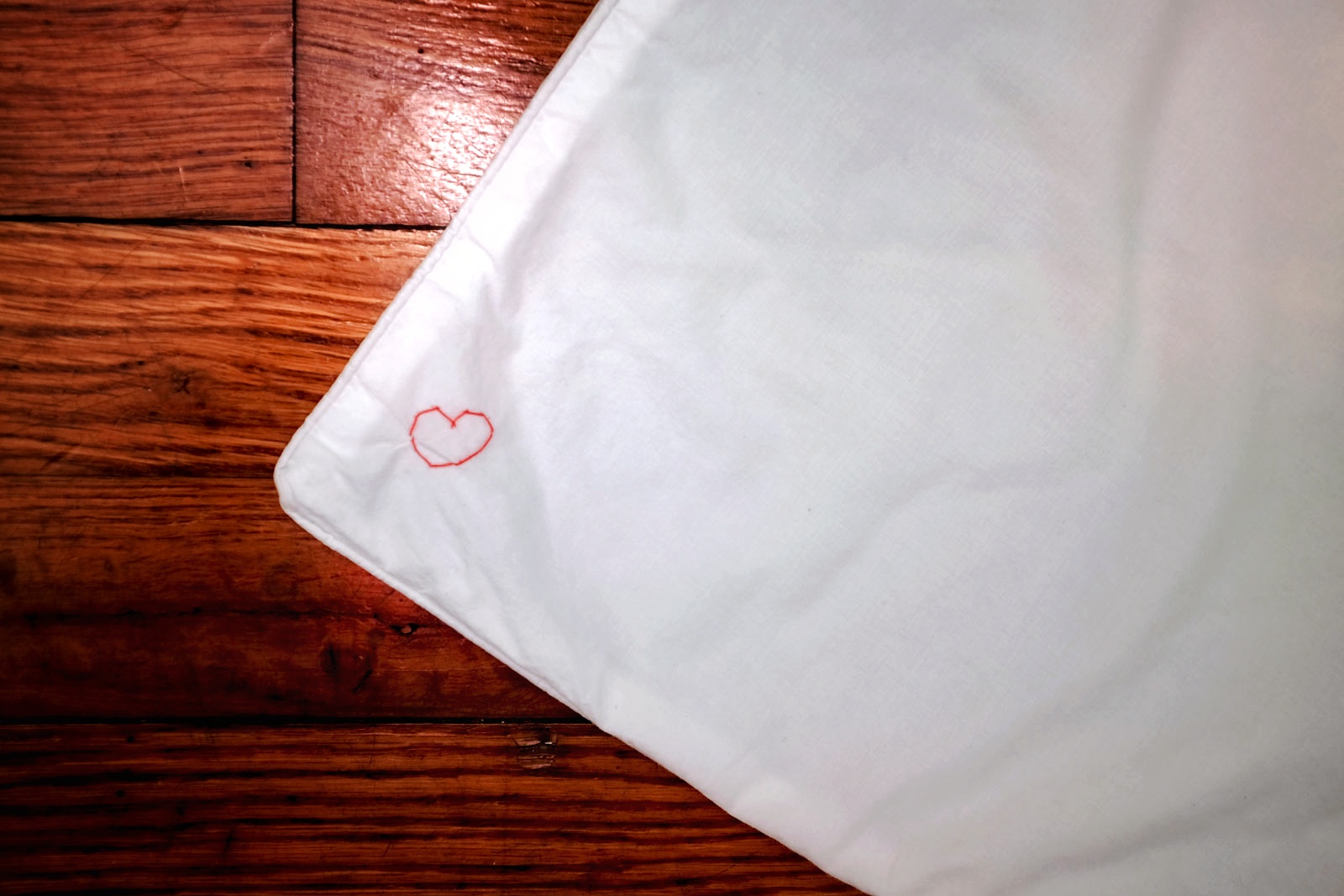 A pillowcase with a heart embroidered on it