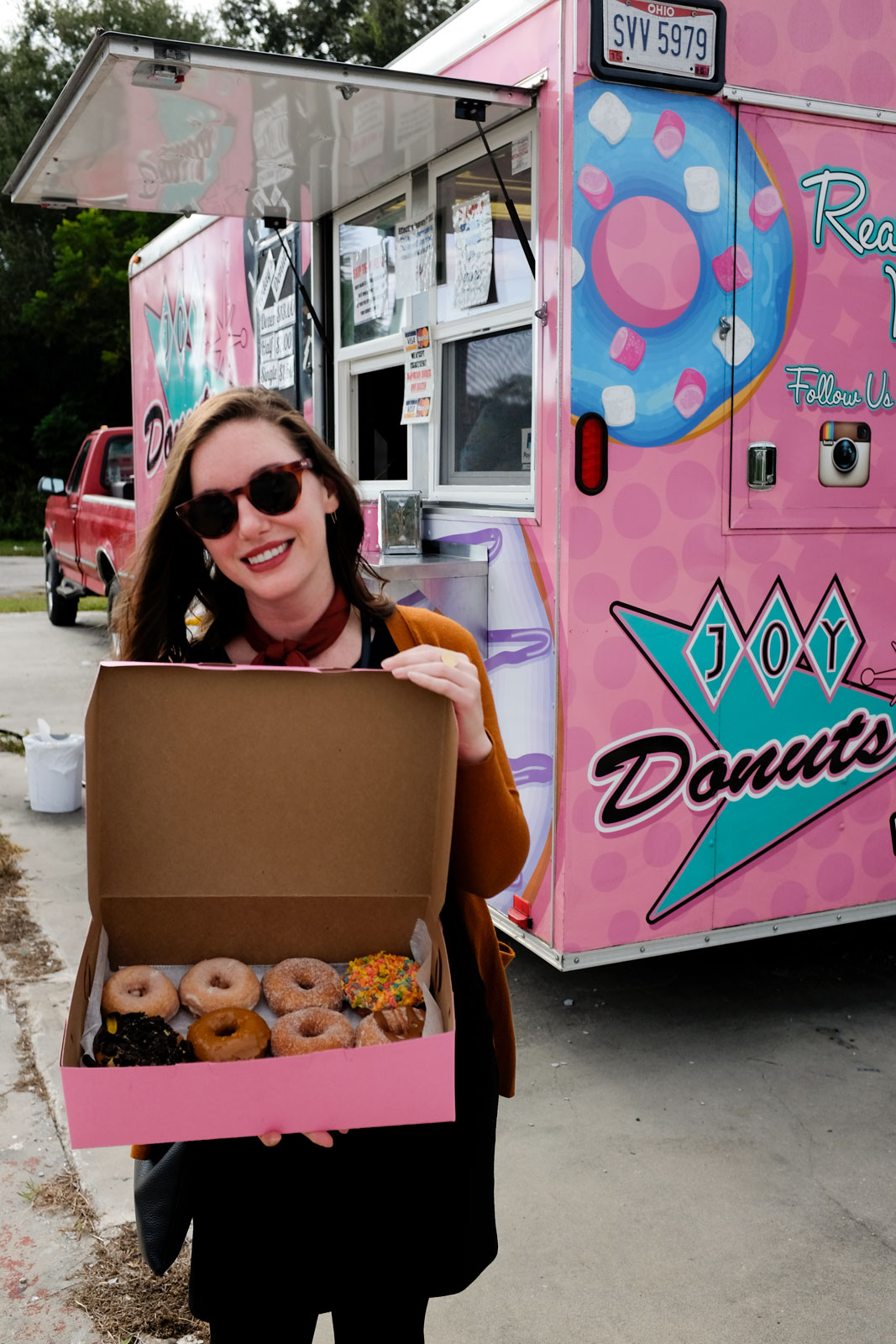 Alyssa holds a dozen donuts from Joy Donuts