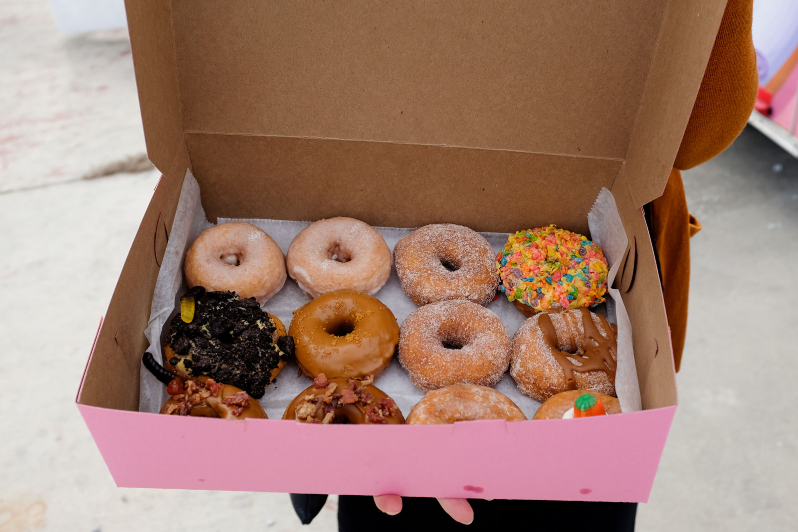 A close up of a dozen Joy Donuts