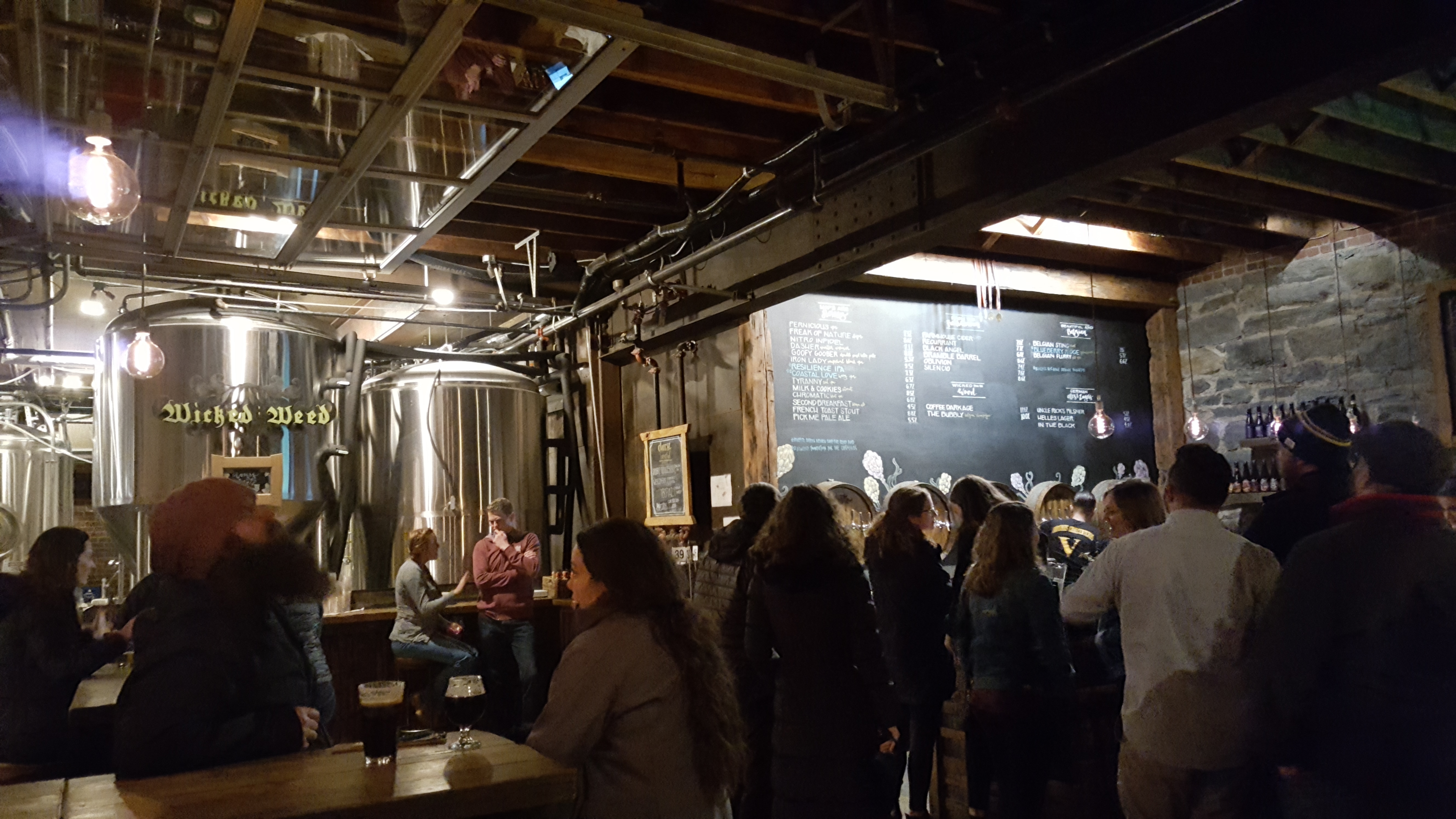 A crowd drinking beers at Wicked Weed Asheville
