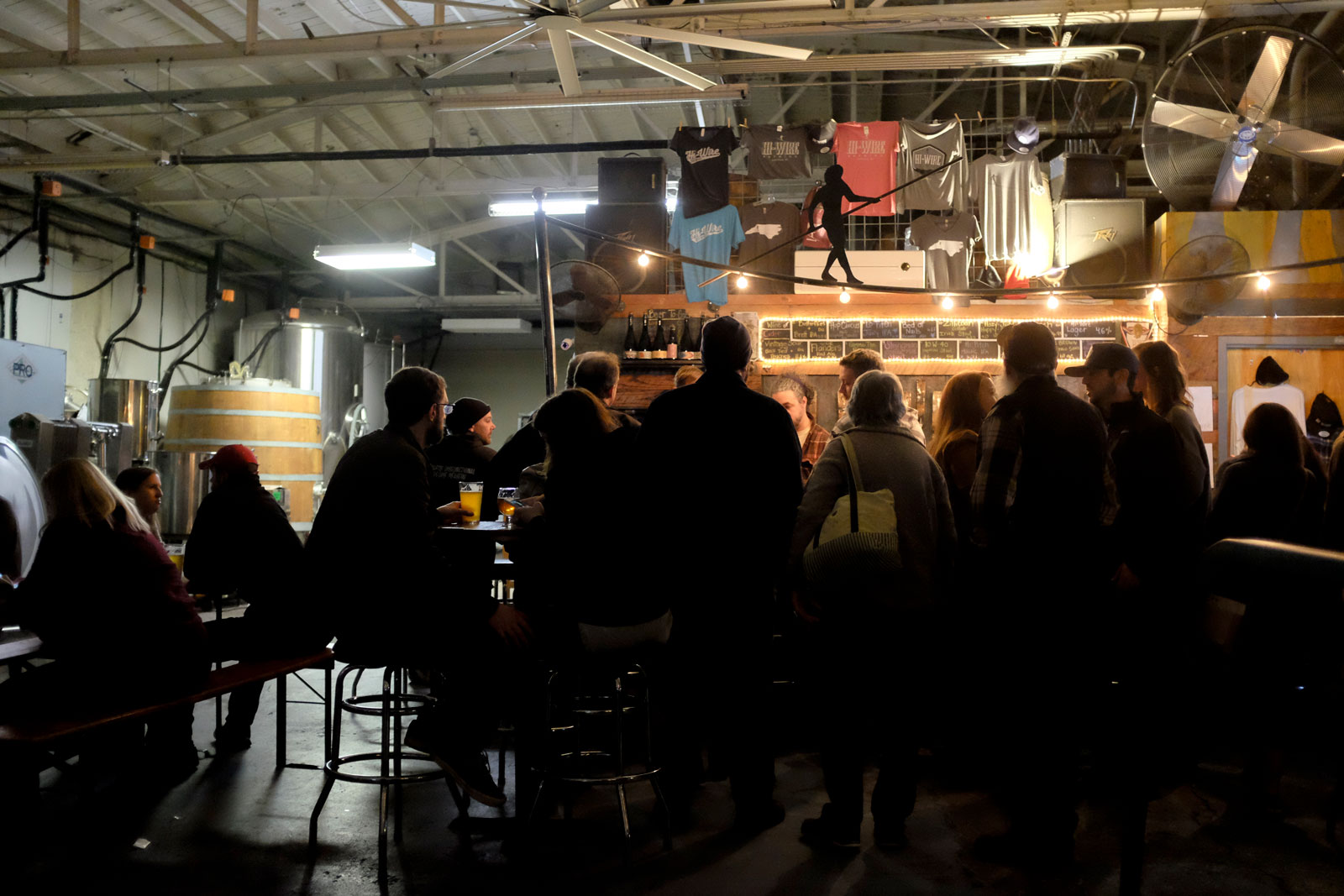 A group of people drinking beer at Hi Wire Asheville