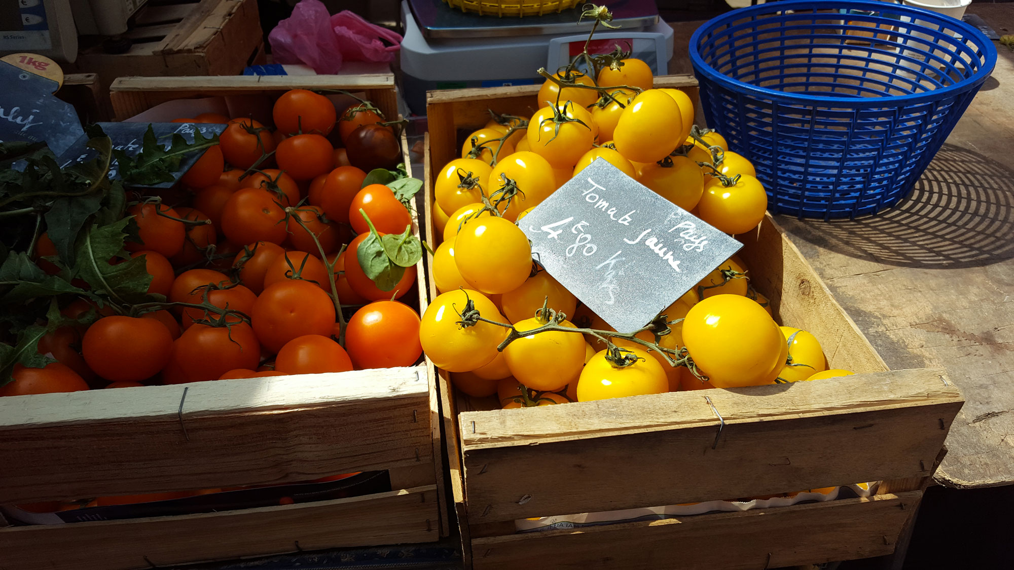 Red and yellow tomatoes in baskets at French farmer's market