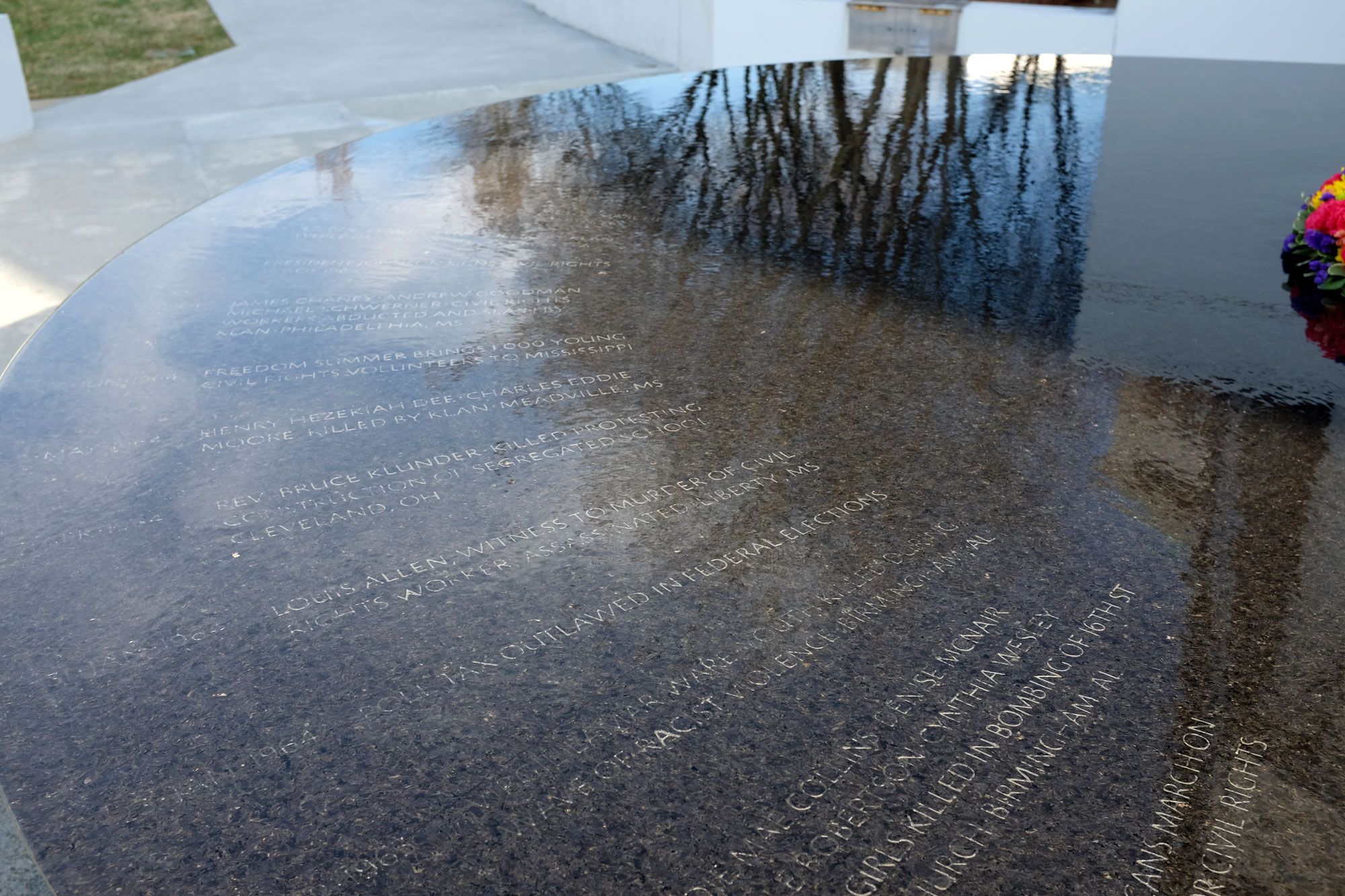Close up of Civil Rights Memorial with inscriptions in stone covered with a thin layer of water
