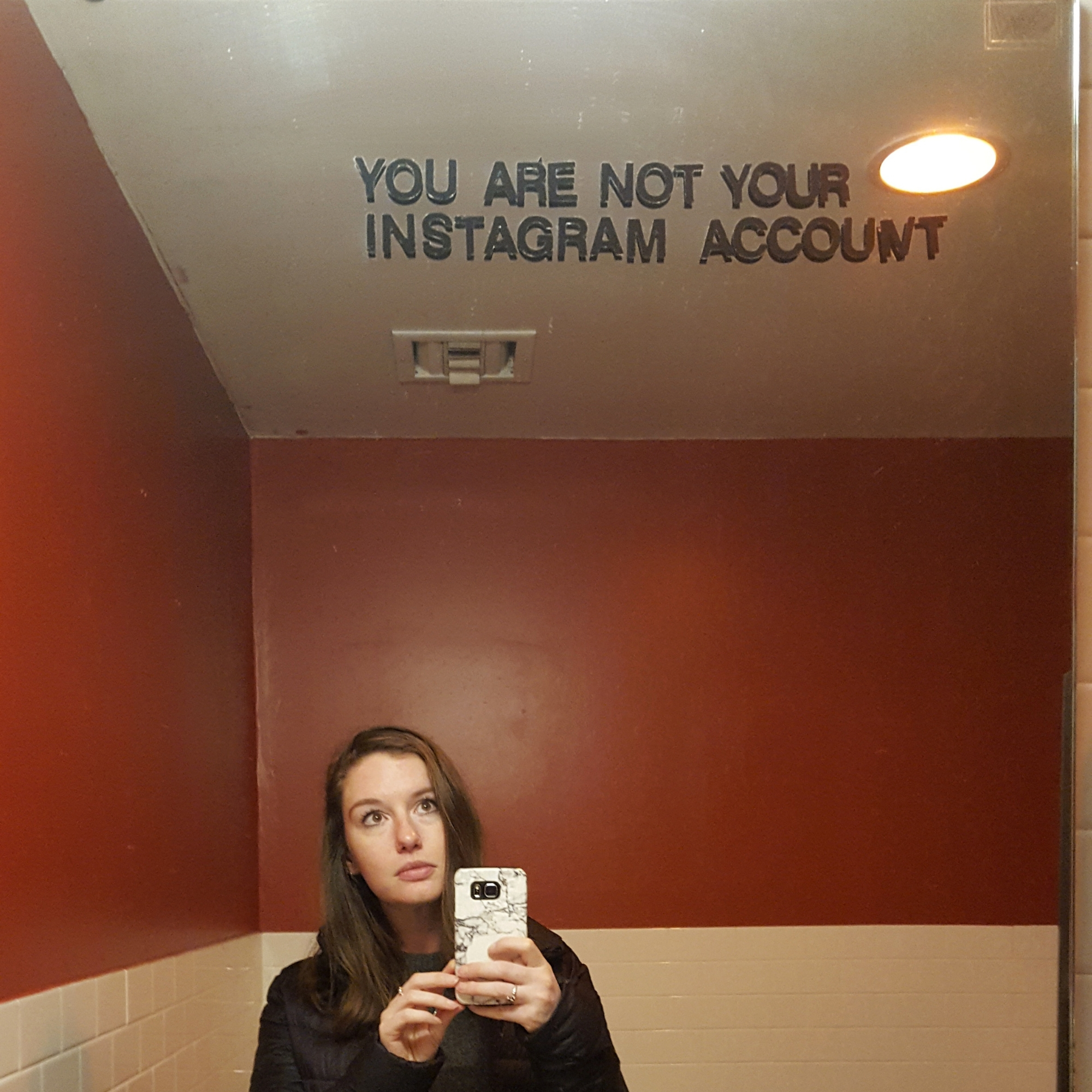 Krystal in a mirror with sign that says you are not your instagram account