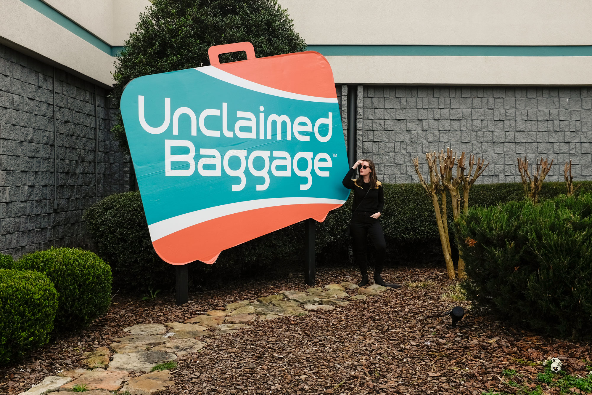 Alyssa standing in front of Unclaimed Baggage sign