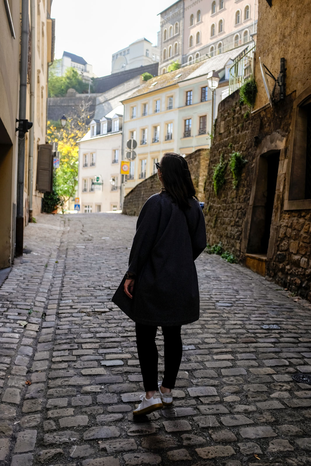 Alyssa walks through a cobblestone street in Luxembourg