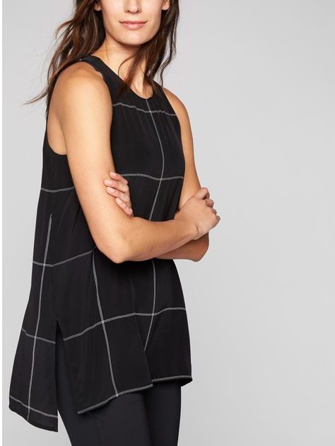 Woman wearing a black tunic with white windowpane plaid print